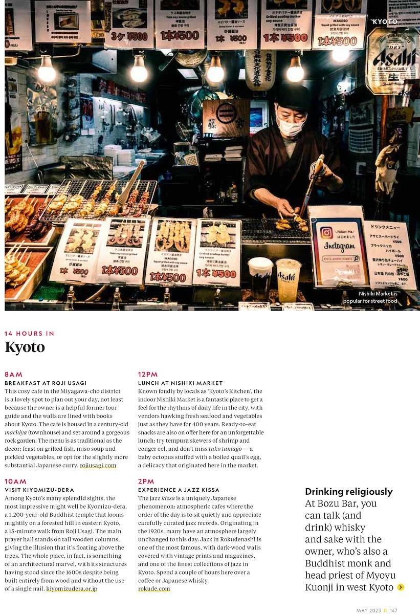 Food stall in Kyoto, Japan, featuring skewers and Japanese drinks with illuminated signs and a person wearing a face mask cooking.