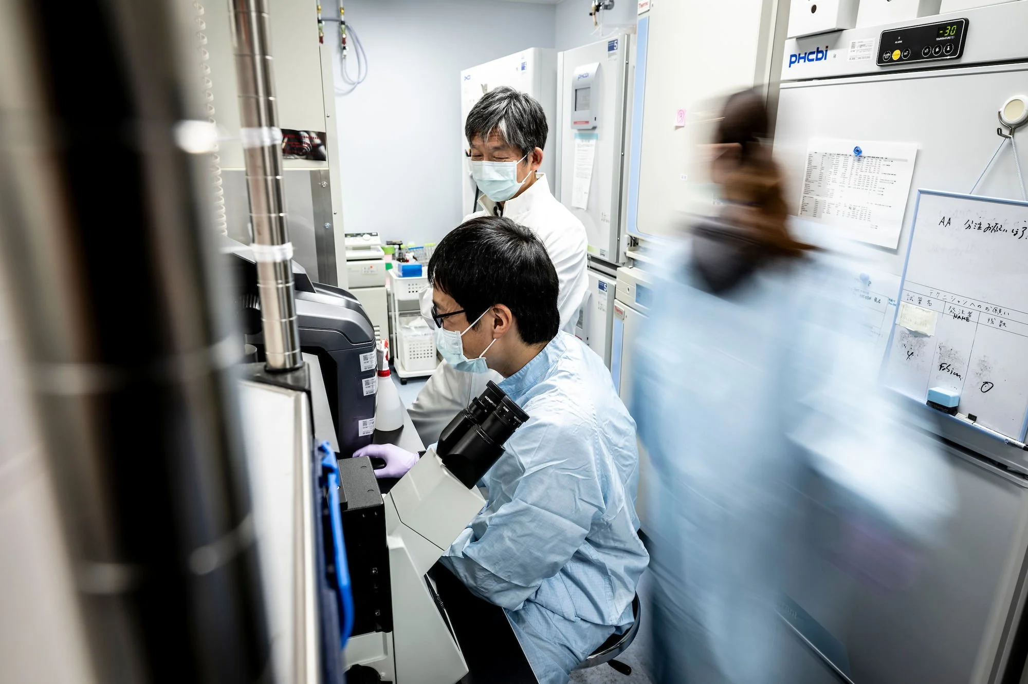 Researchers conducting experiments in a modern science lab photographed for an editorial science journal.