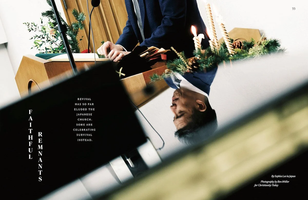 A reflection of a man in a piano, with decorated candles and greenery, and text about faith and revival in the Japanese church, photographed by editorial photographer Ben Weller.