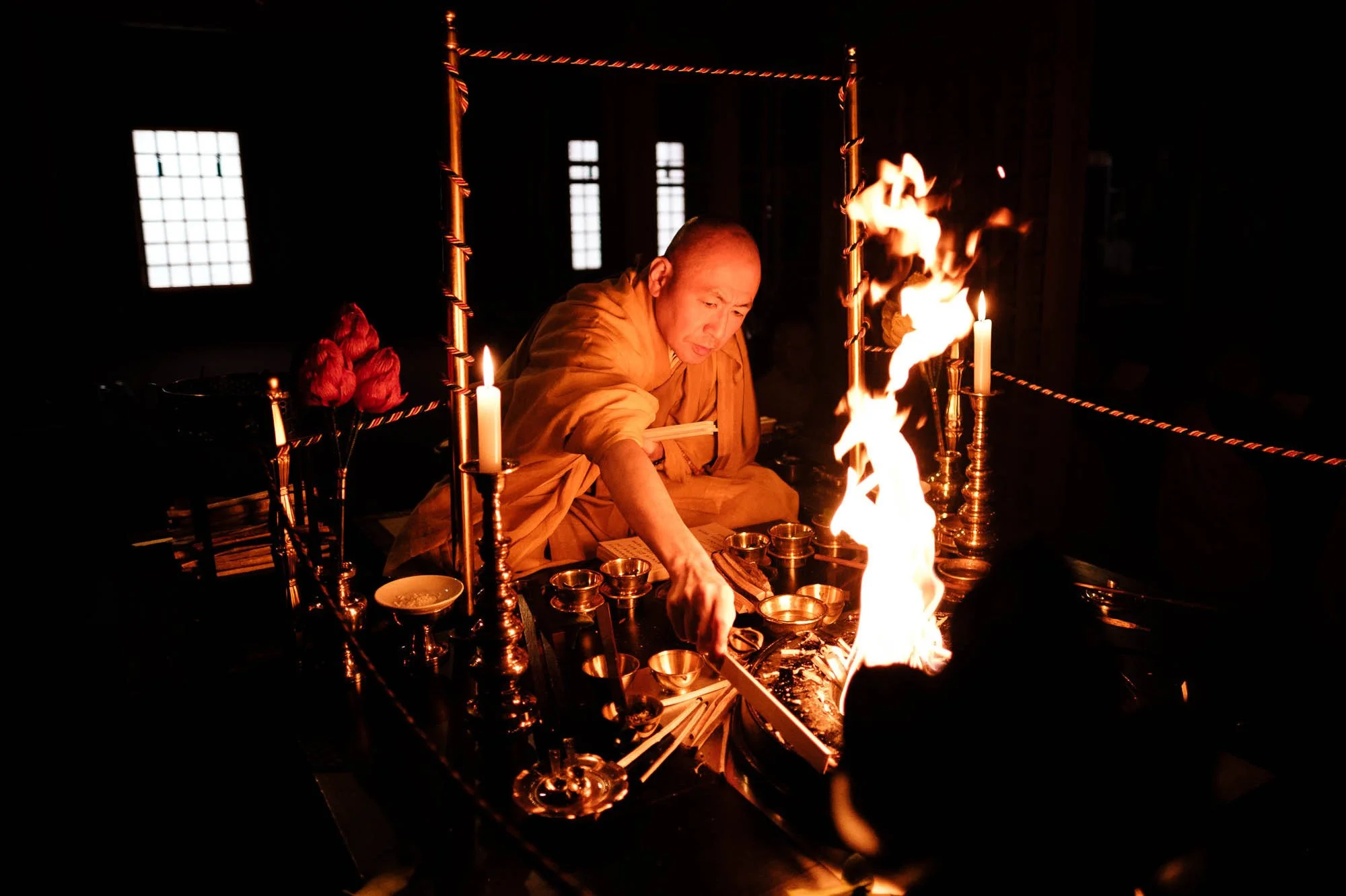 Japanese Buddhist monk burning wooden prayer sticks during a morning ceremony at a temple in Koyasan, Wakayama Prefecture, Japan.