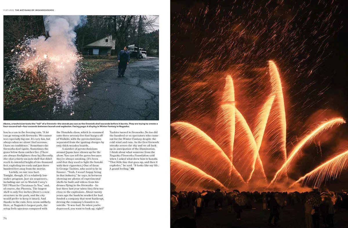 A person watching fireworks, with a display of large, bright, golden fireworks bursting in the night sky. A crowd of spectators is seen in the foreground.