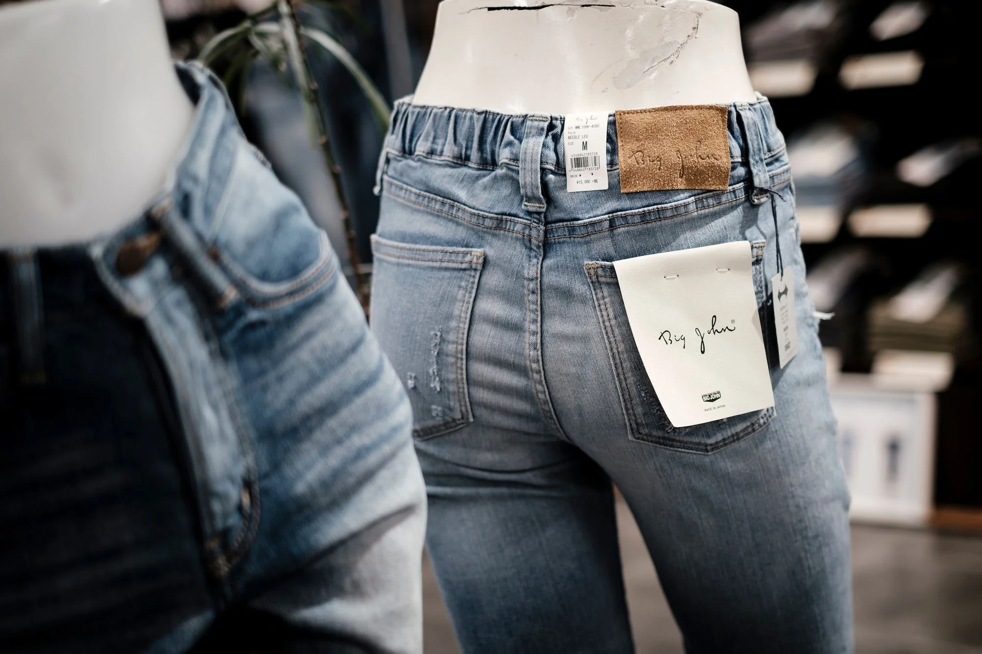 Denim jeans displayed on mannequin in boutique fashion store.