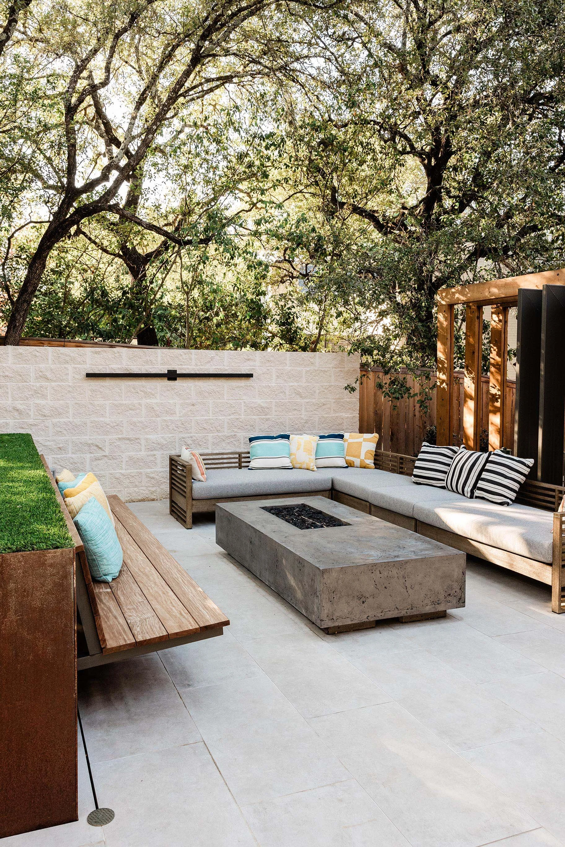 Side view of fire pit area showing rusted steel planters, integrated seating, and stone accents