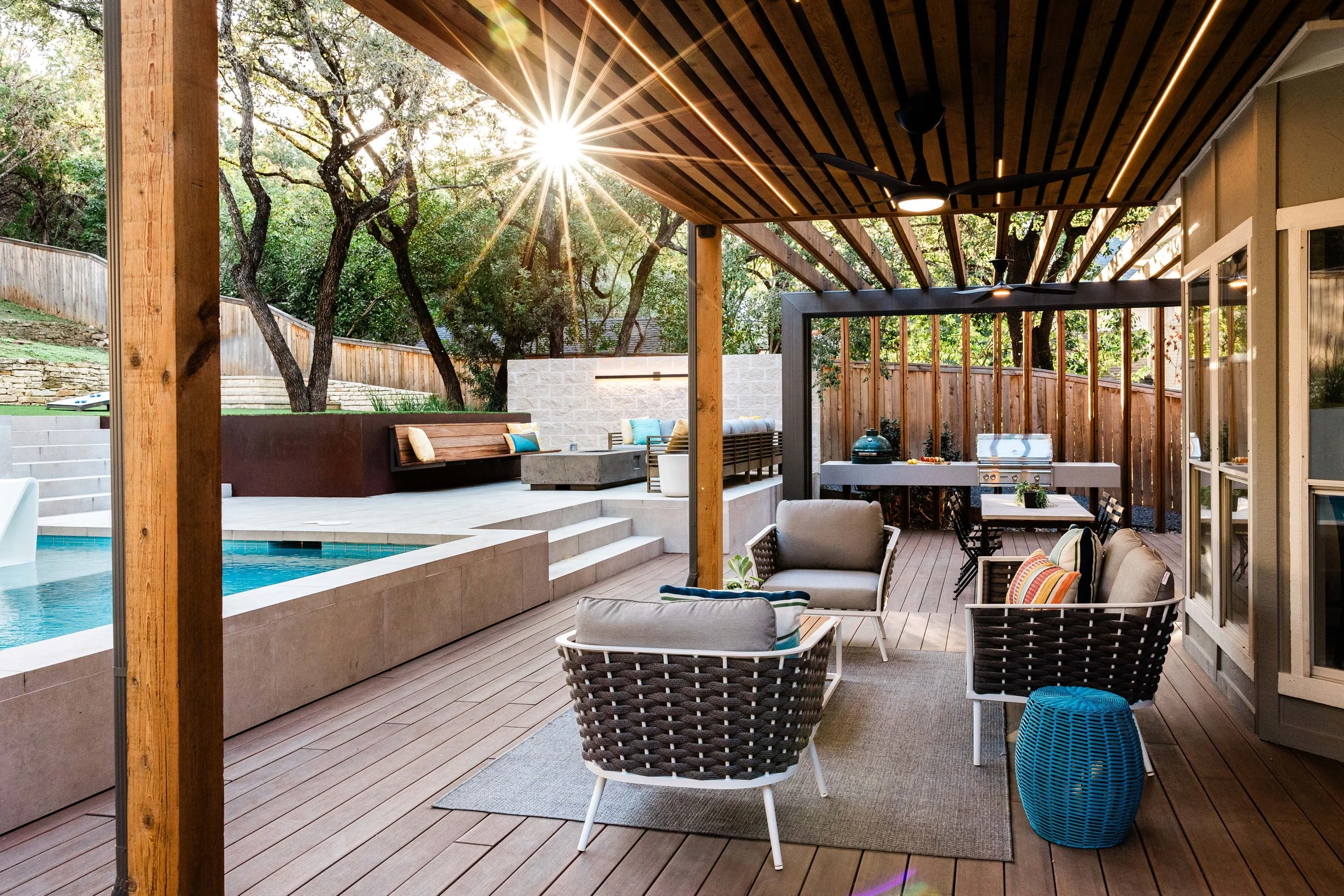 Sleek outdoor seating area with built-in bench, L-shaped couch, and concrete fire pit against stone wall
