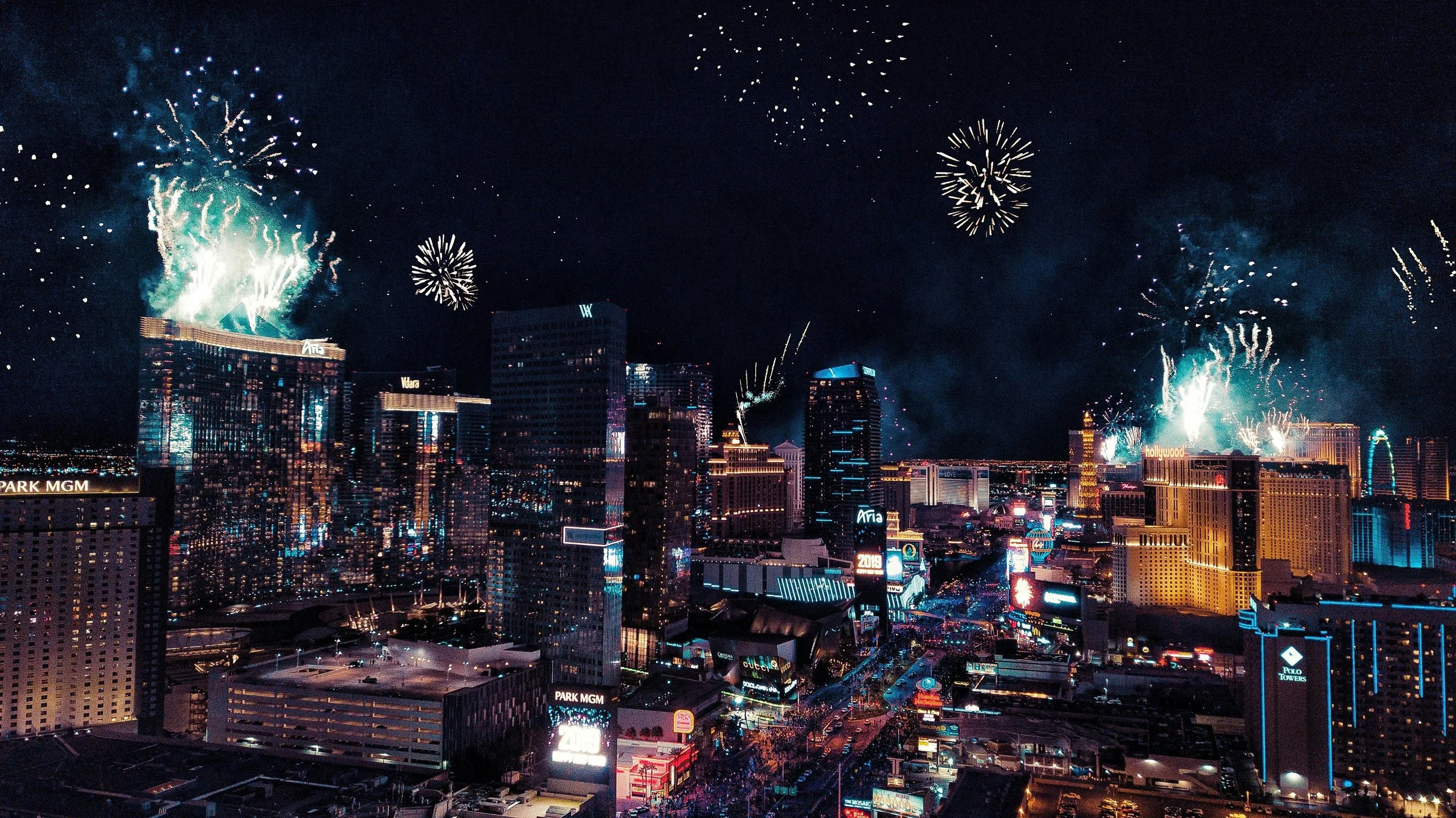 Festivités nocturnes avec feux d'artifice illuminant le ciel au-dessus du centre-ville de Las Vegas, avec de nombreux gratte-ciel et enseignes lumineuses.