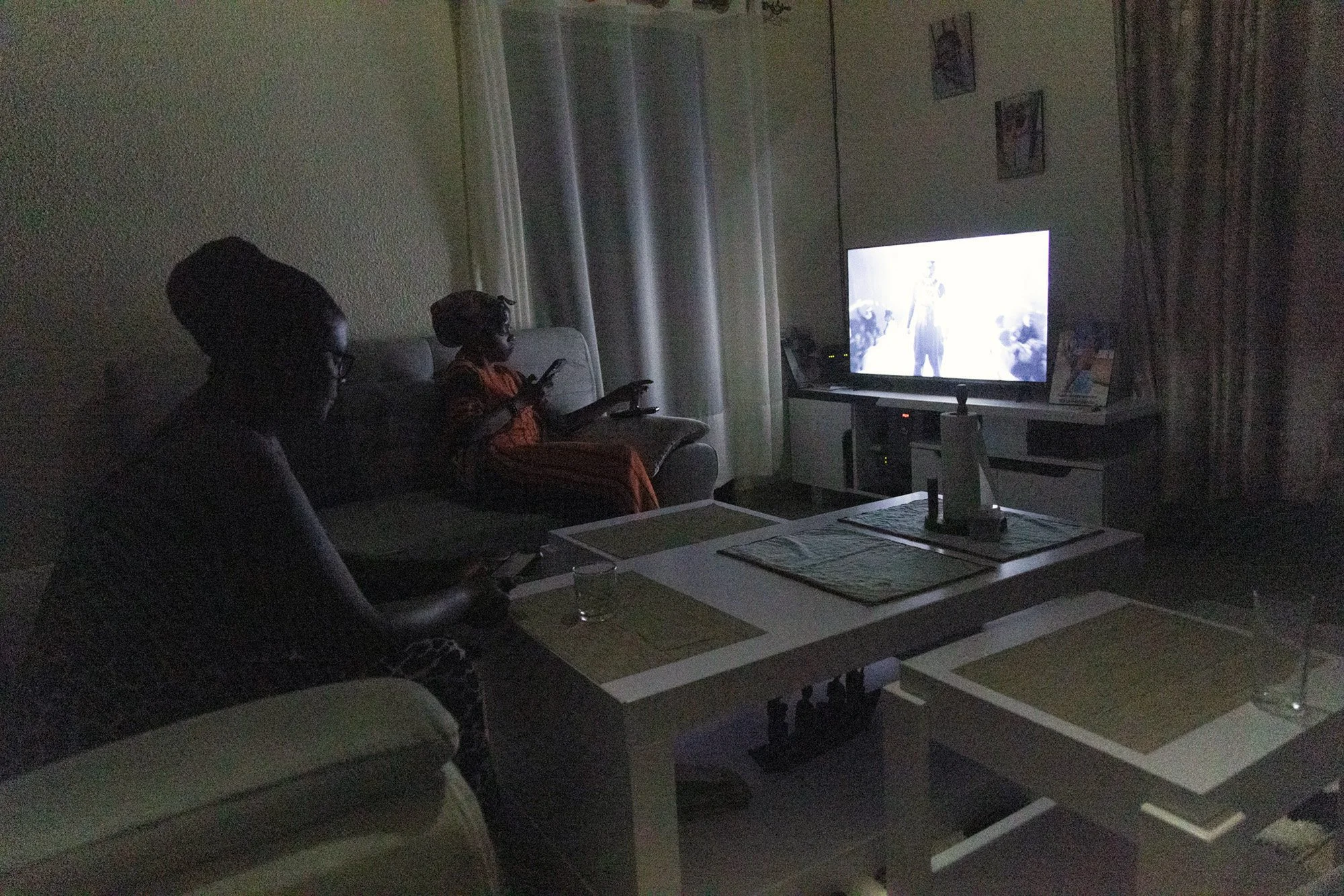 From left, Mary Nyangoma, Founder of Nyamirambo Women’s center and daughter, Hamida Umuhoza watching television before another hard day at work on July 8, 2024, in Kigali, Rwanda.  
