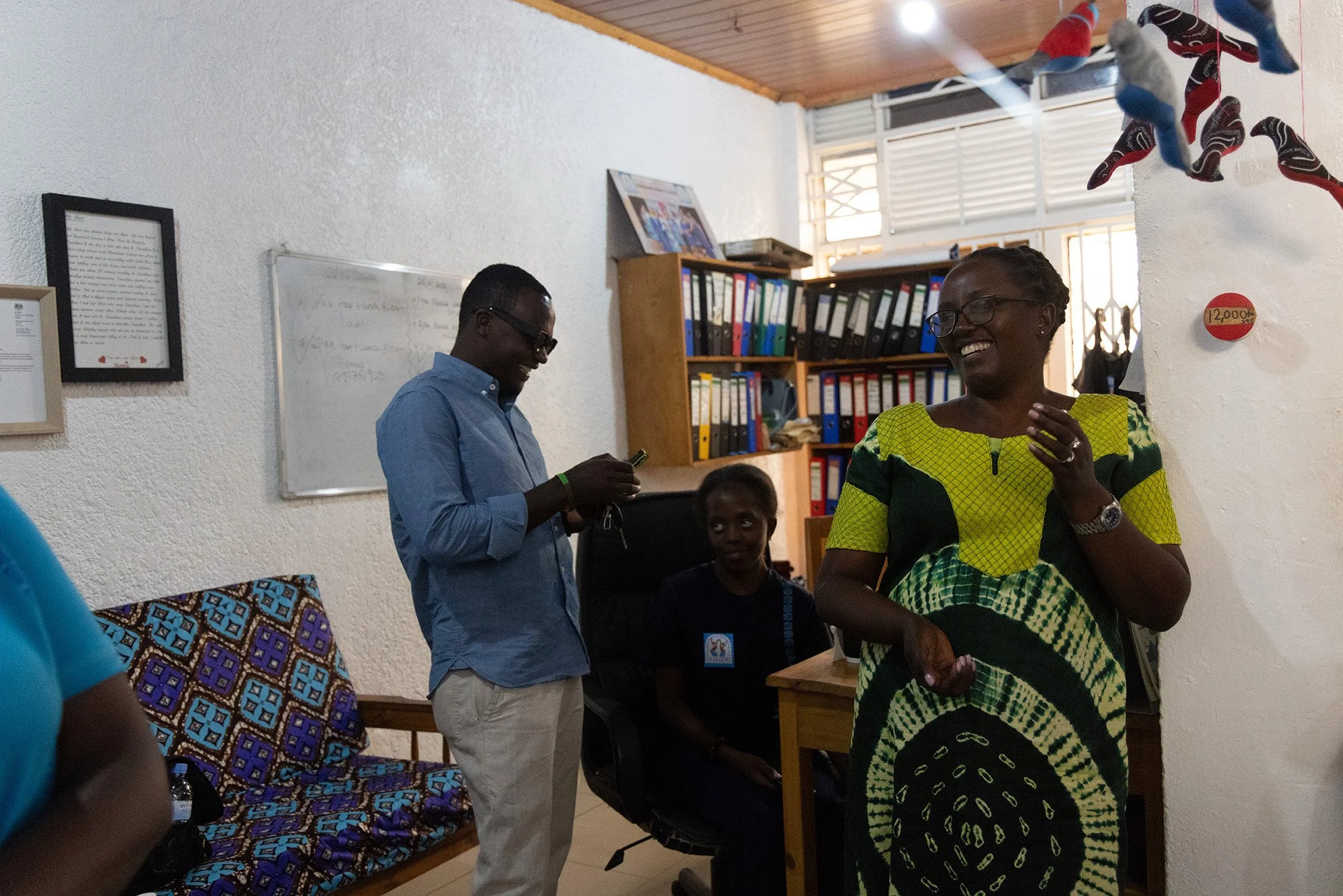 From left, Hagenimana Jean de Dieu, Hamida Umuhoza, Mary Nyangoma, founder of Nyamirambo Women’s center, making jokes at work with co-workers on July 5, 2024, in Kigali, Rwanda. 