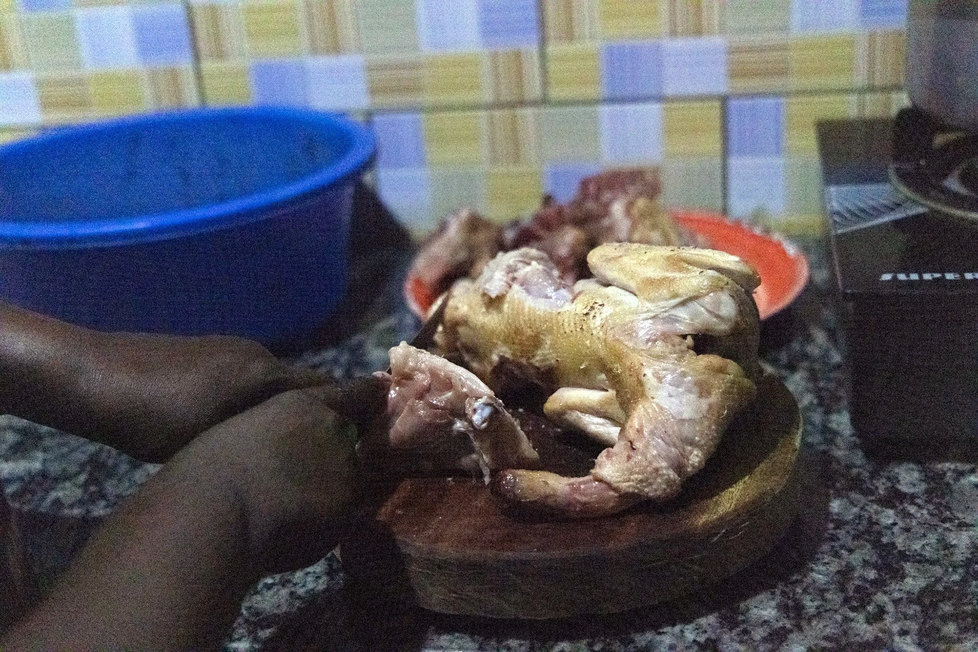 Mary Nyangoma, founder of Nyamirambo Women’s center, prepares chicken for her family on July 8, 2024, in Kigali, Rwanda. 