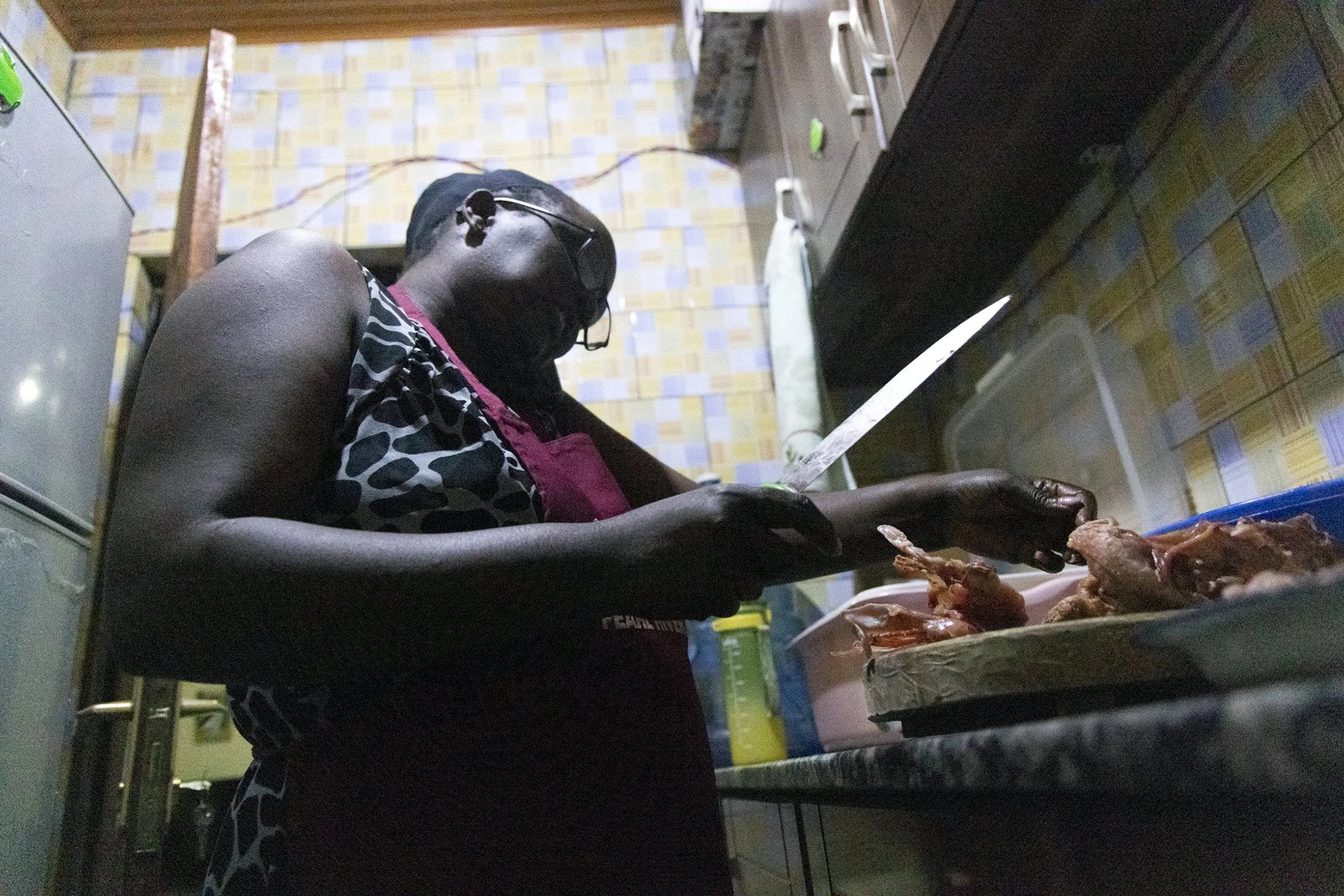 Mary Nyangoma, founder of Nyamirambo Women’s center, cooks chicken for boyfriend and daughter on July 8, 2024., in Kigali, Rwanda. 