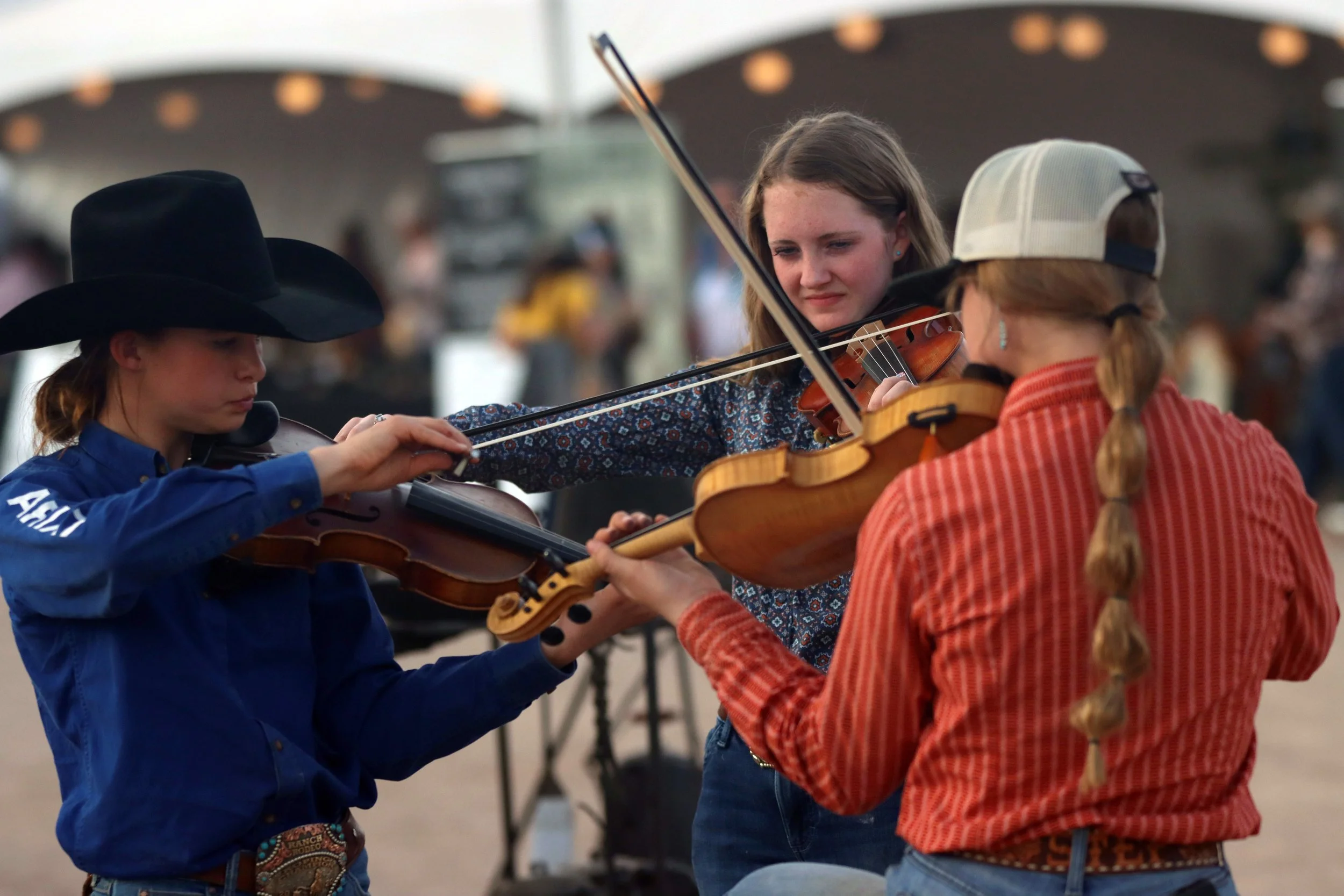 From left, Jayla Reed, Lacey Richardson and Madison Kenny play with their band, The Reed Family, on Jan. 19, 2024. Their favorite music to play is fiddle and bluegrass. “We have had so much fun learning and performing songs that have been forgotten b
