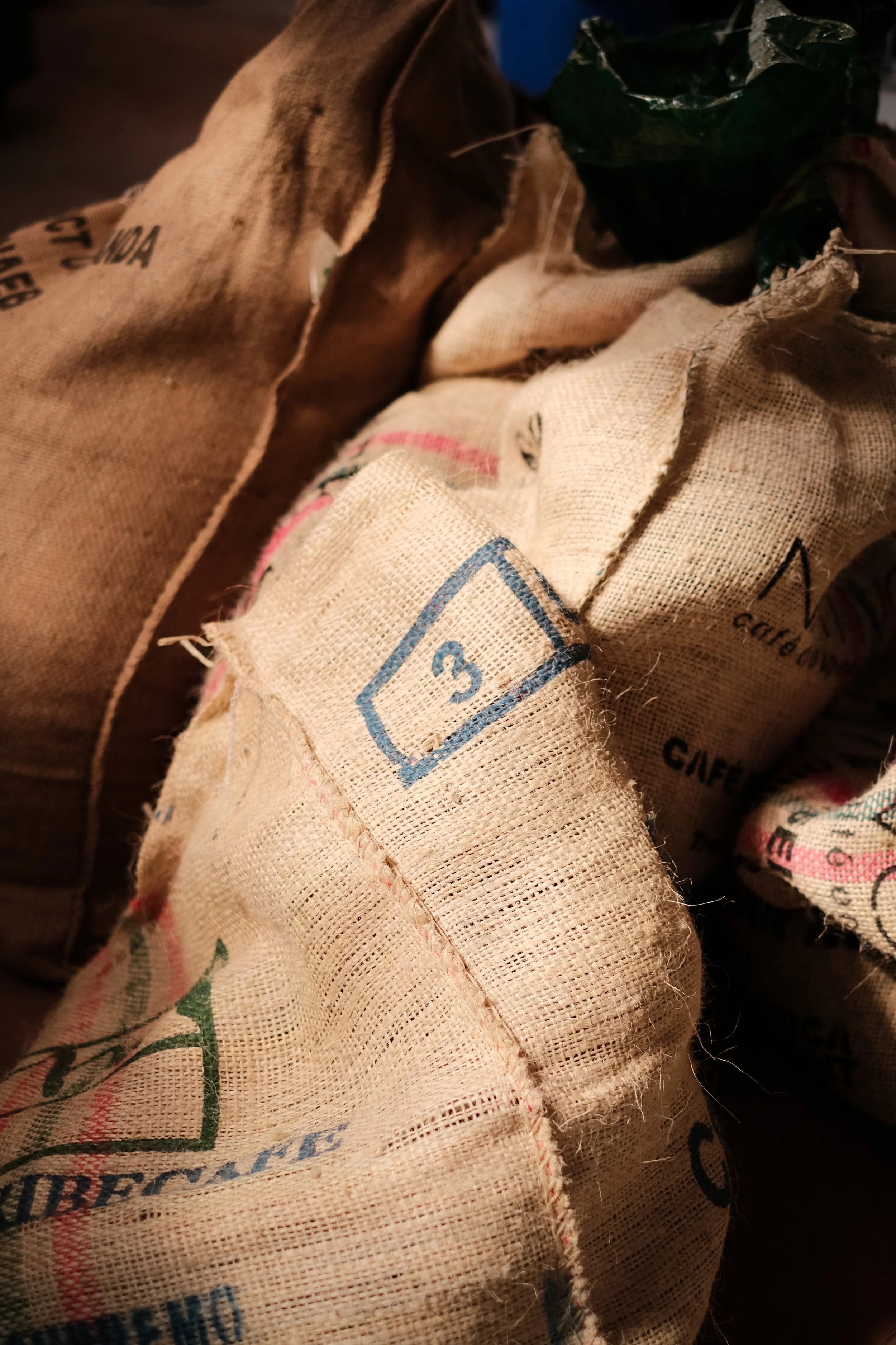 Sacs de café vert de Colombie et du Rwanda dans l'atelier de Dialogue Torréfaction