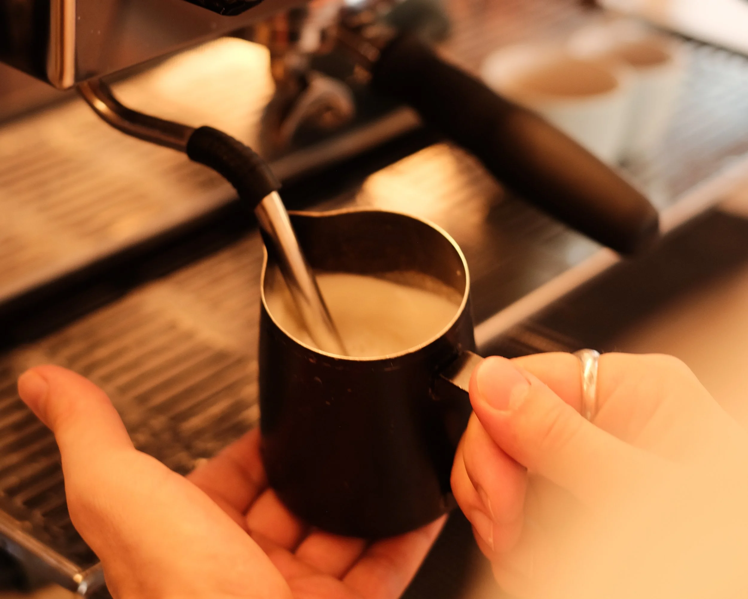 Texturation du lait pour la préparation d'un cappuccino sur machine La Marzocco à Lyon