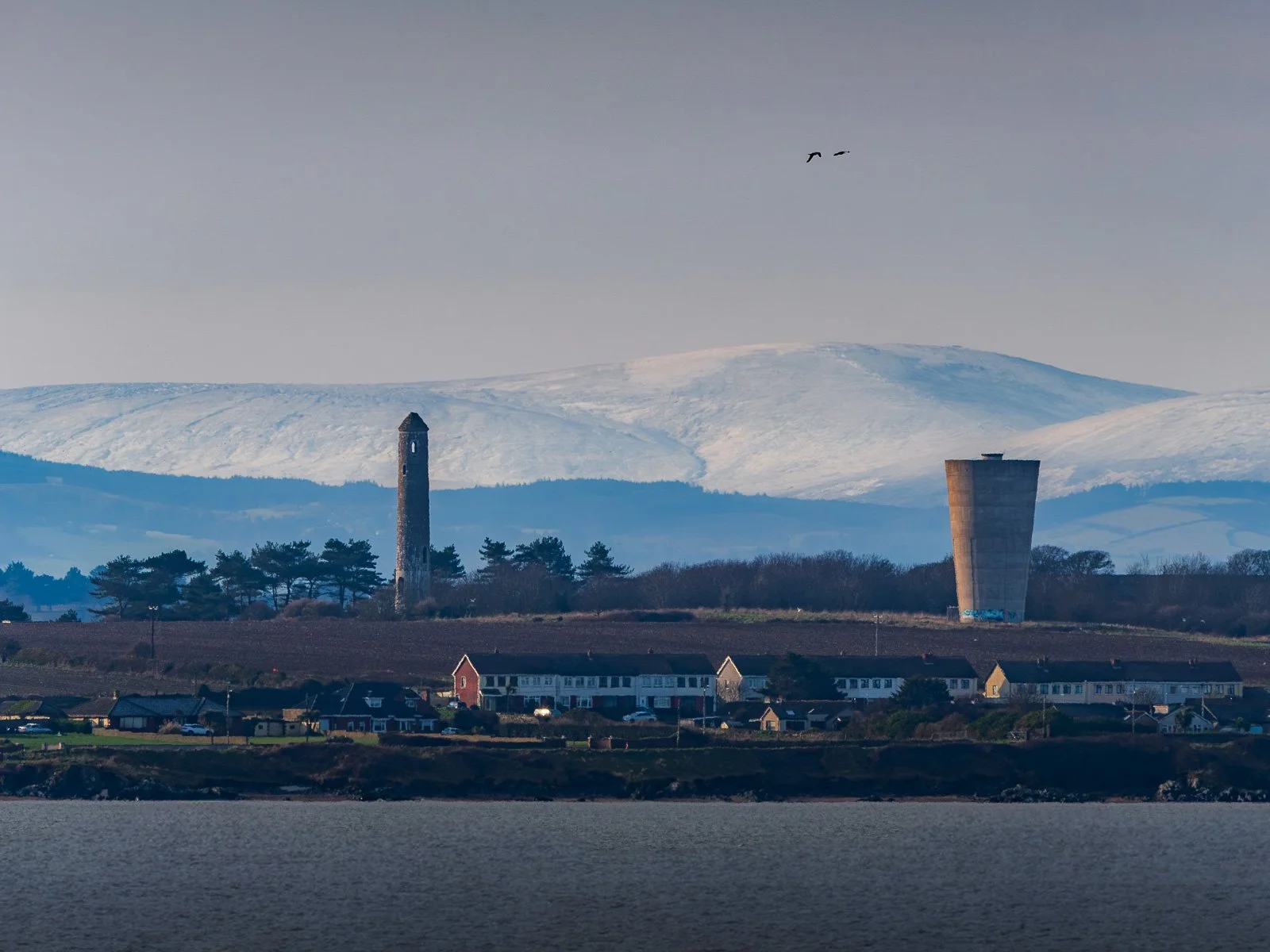2026-02-14 Portrane towers with snowy Wicklow Mountains from Rush.jpg