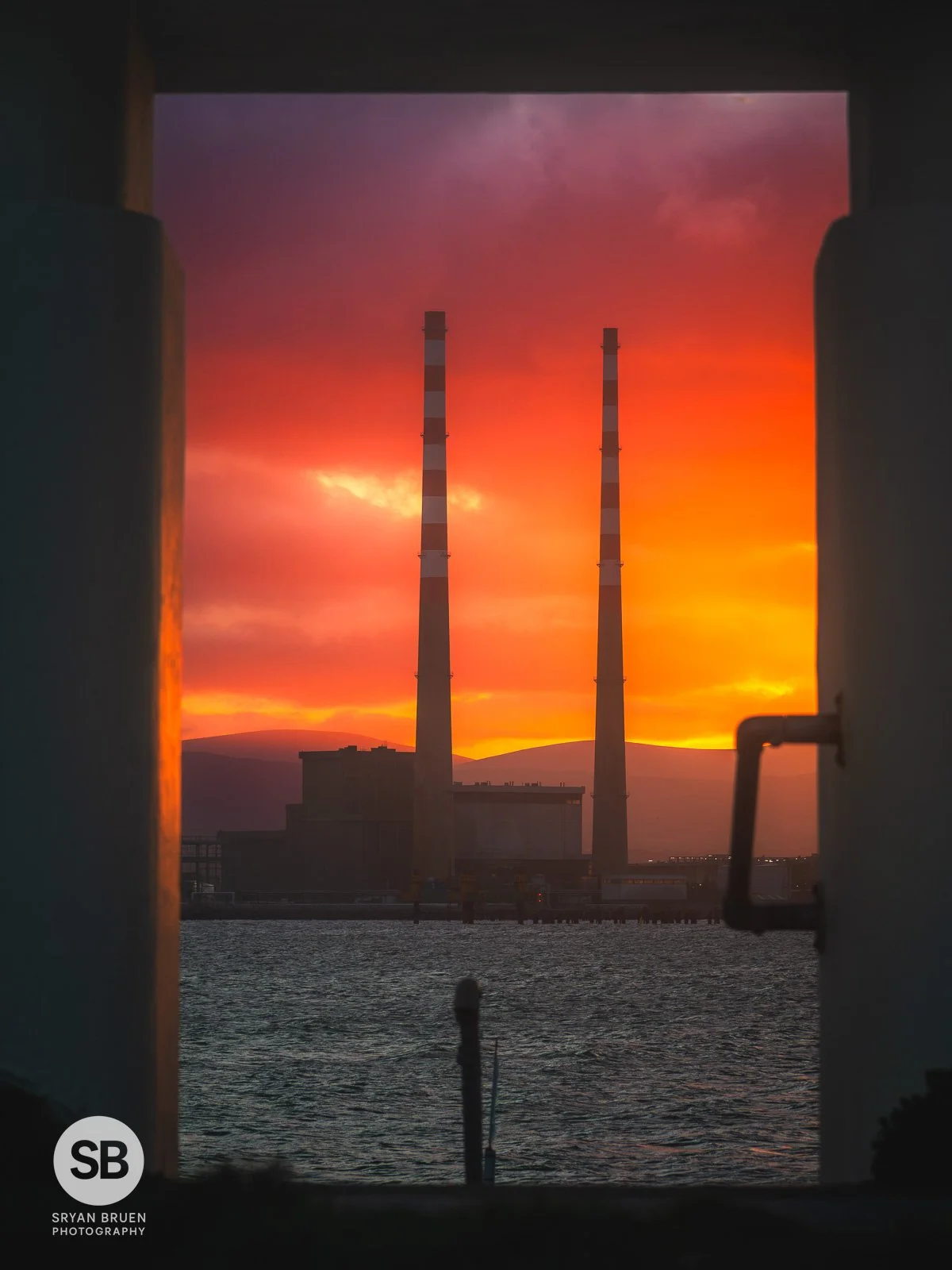 2025-12-24 Poolbeg sunset sky through the ladies shelter at the Bull Wall.jpg