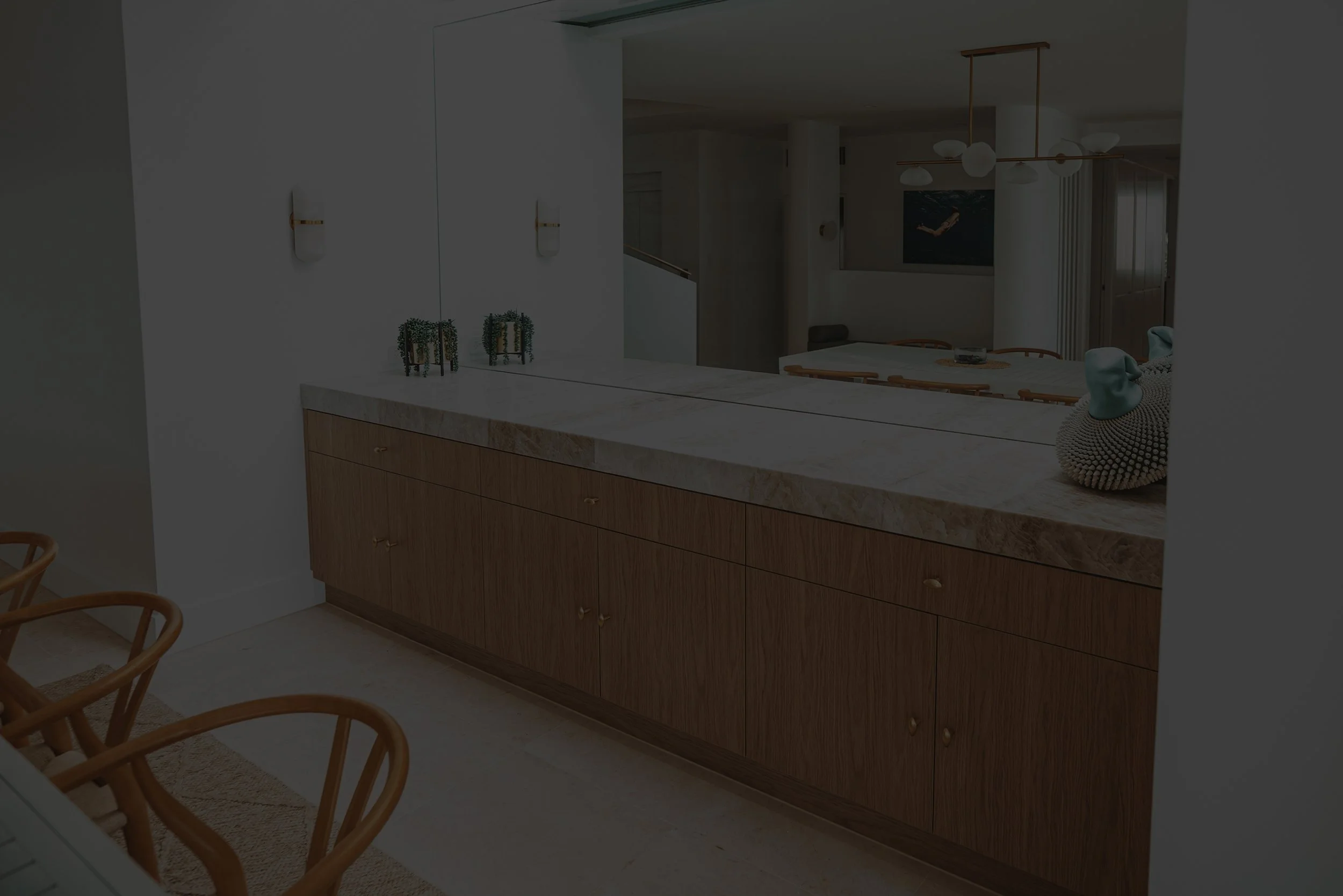 Interior of a modern kitchen with a marble countertop, wooden cabinets, and minimalist decor.