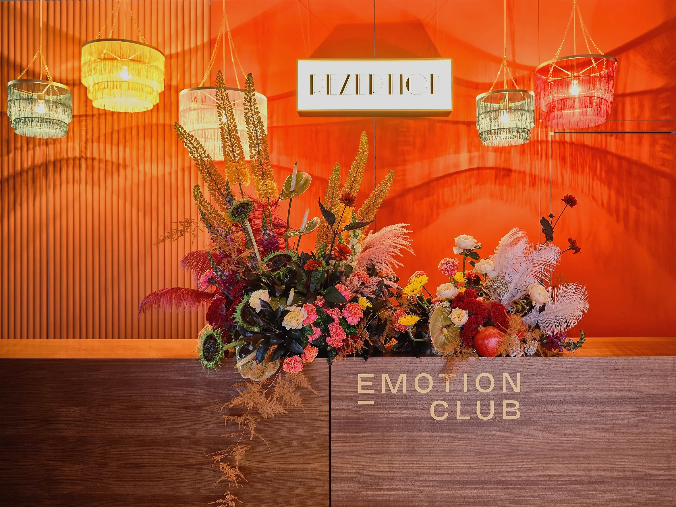 Luxury event floral design with feathers, lisianthus and helianthus at Formula E Berlin 2025 Emotion Club reception desk
