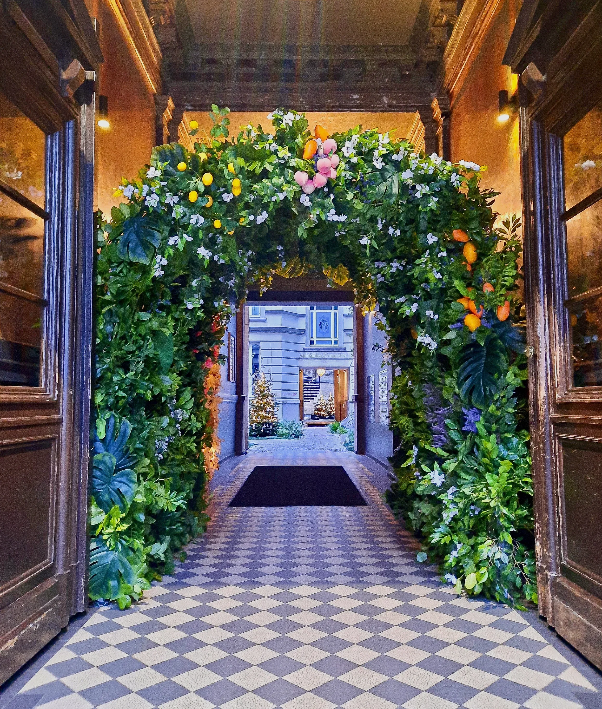 Large-scale flower arch installation with fruits and foliage at Gorki Apartments Berlin 2024