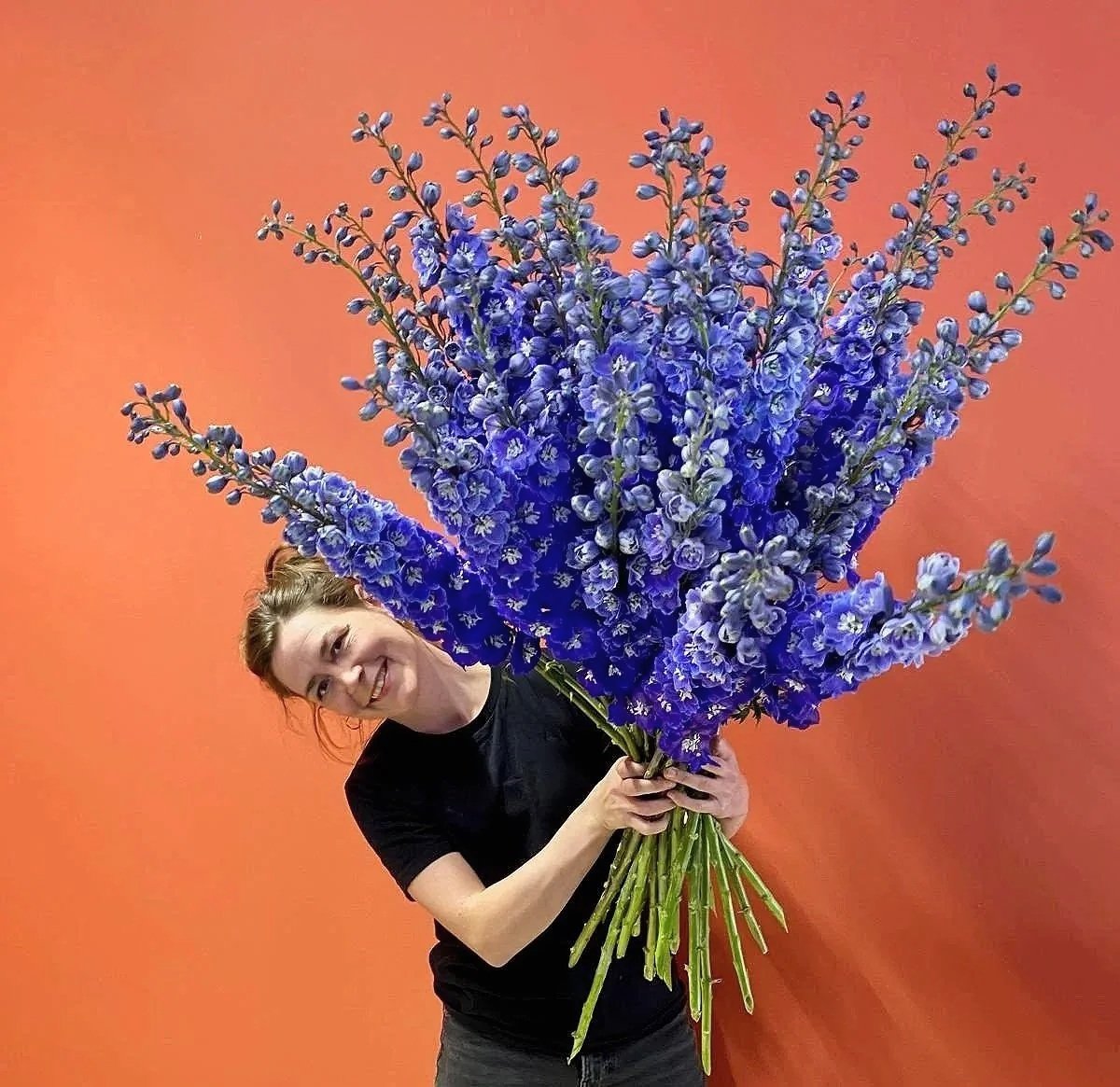 Meike Heller Berlin floral installation artist holding large delphinium bouquet