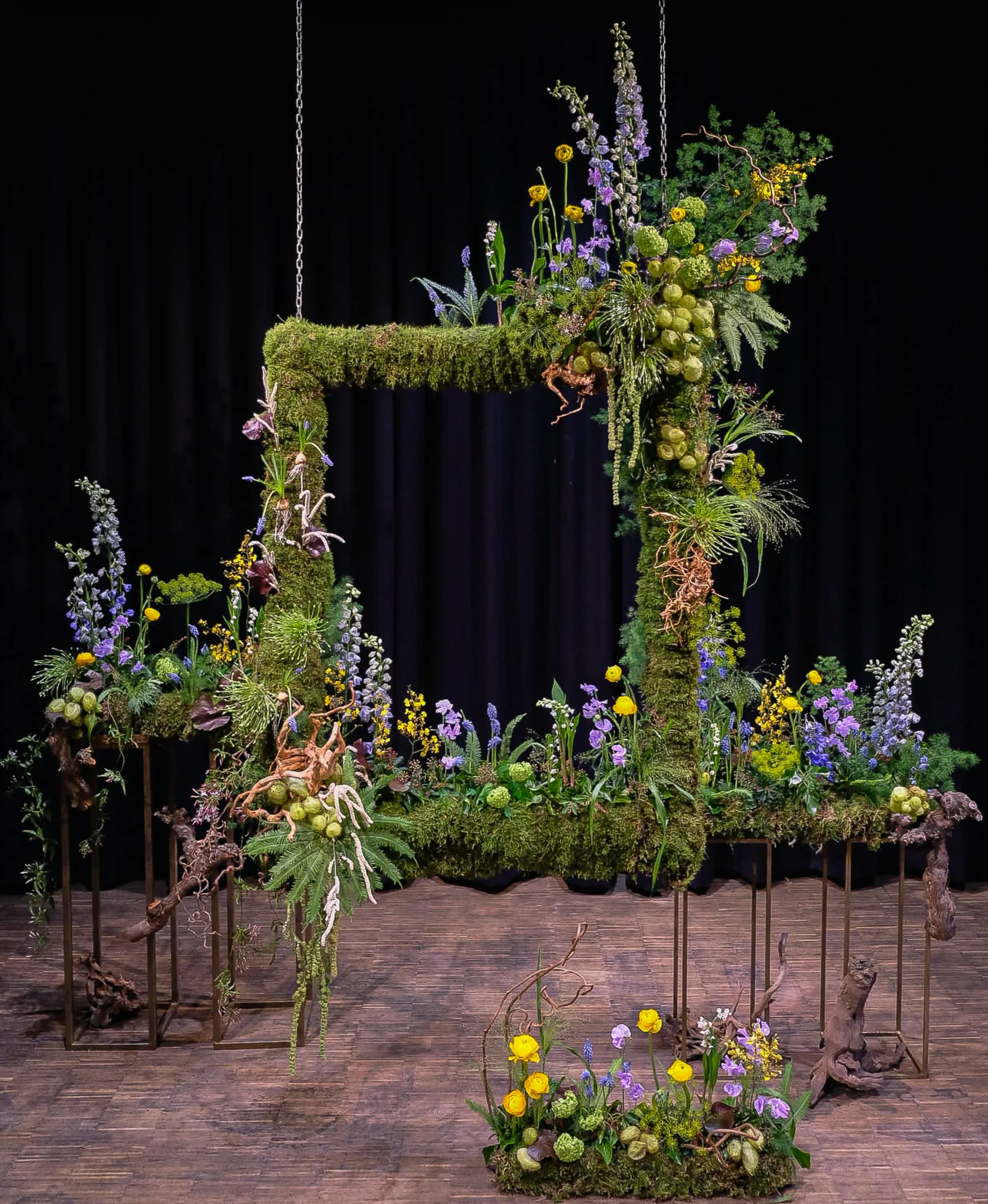Floral frame installation with delphinium, moss and marigold at McQueens Flower School London 2025