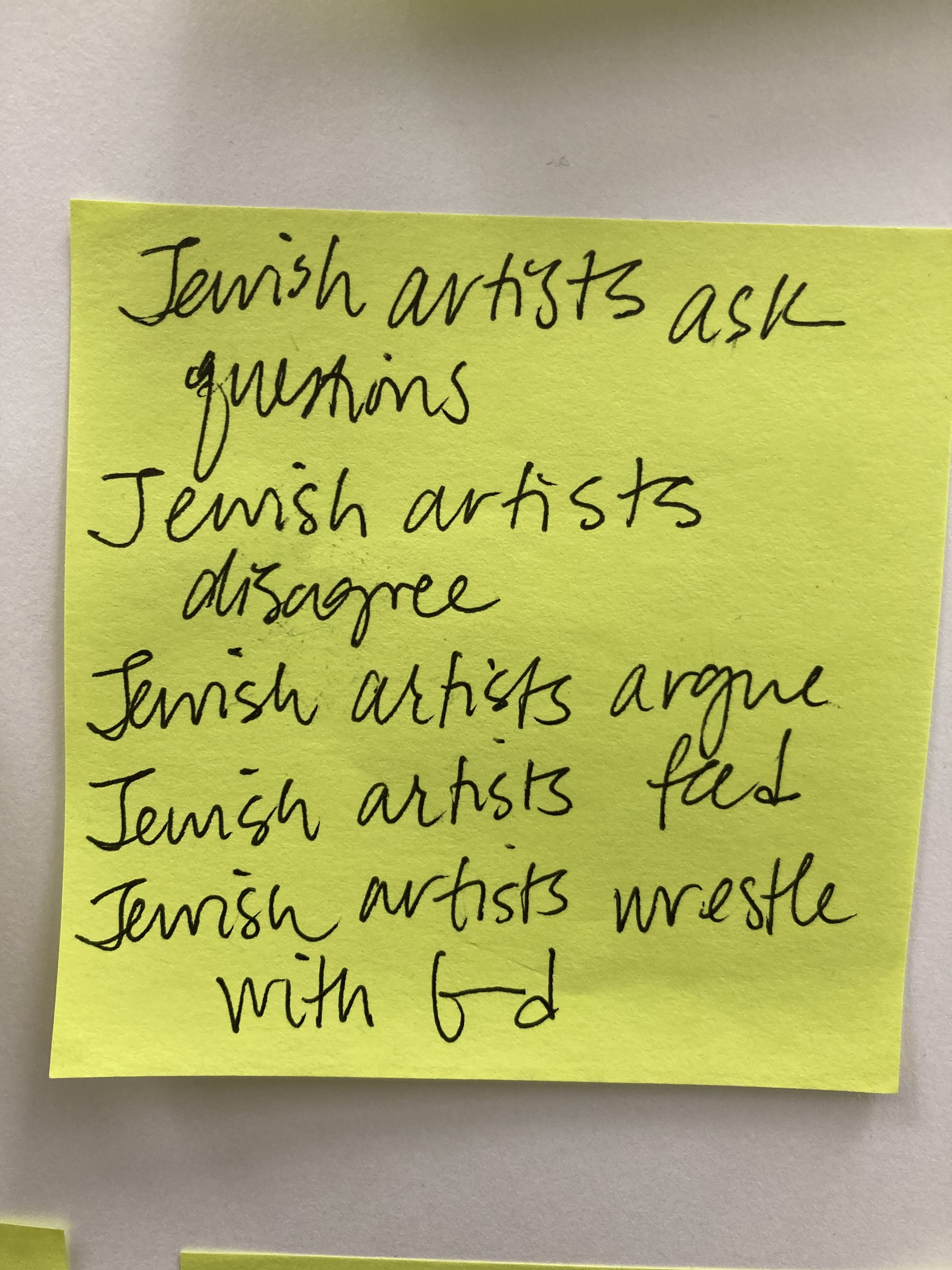 A yellow sticky note with handwritten notes about Jewish artists and questions/disagreements.
