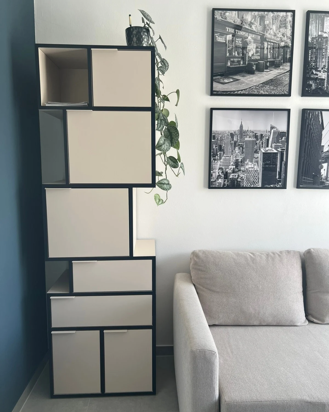 Interior Design Projekt: stilvolles Regal mit dekorativer Pflanze, Teil eines Sofas und moderner Bildergalerie an der Wand