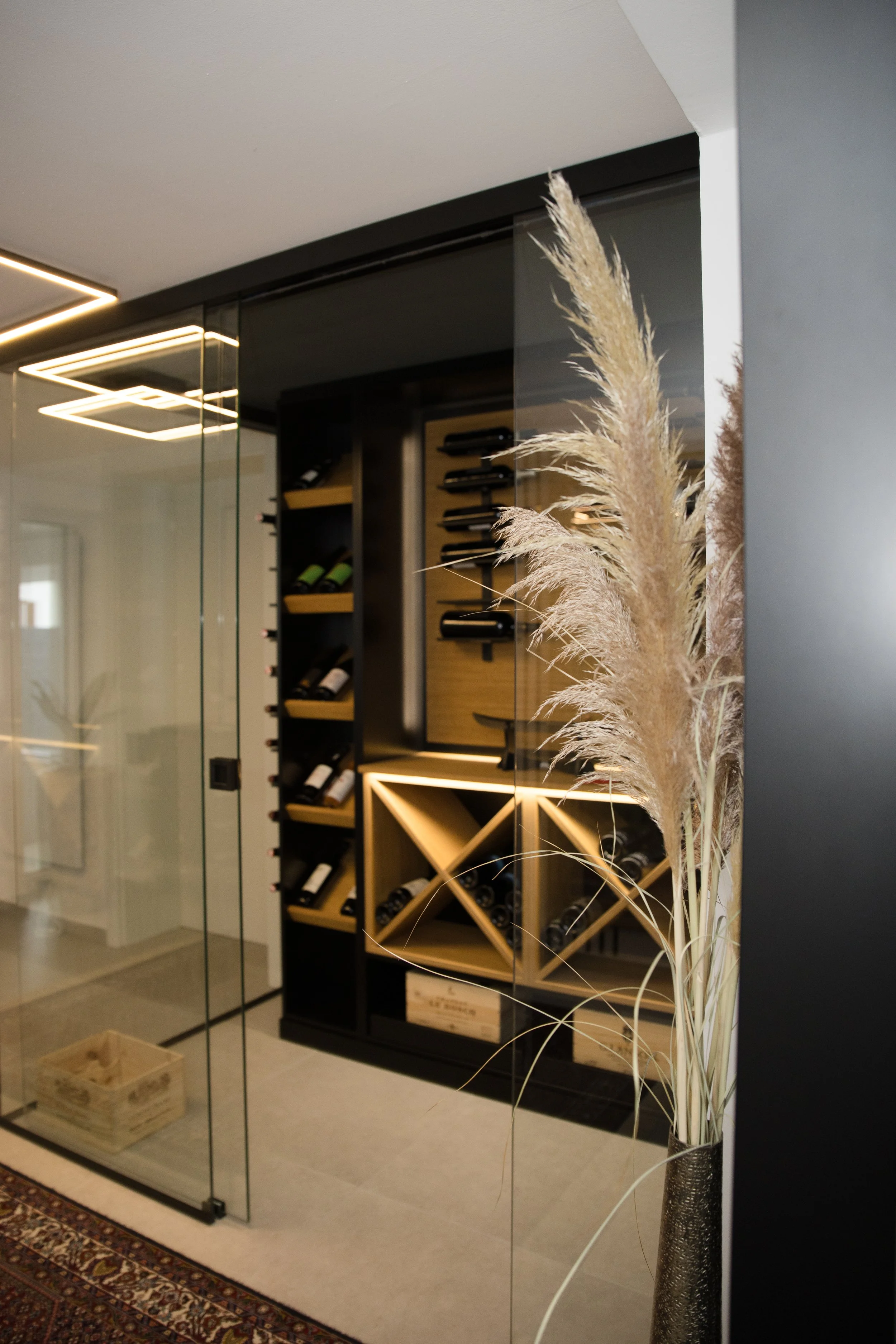 Moderner Weinkeller im Eingangsbereich mit Glaswand, Beleuchtung und stilvollem Interior Design
