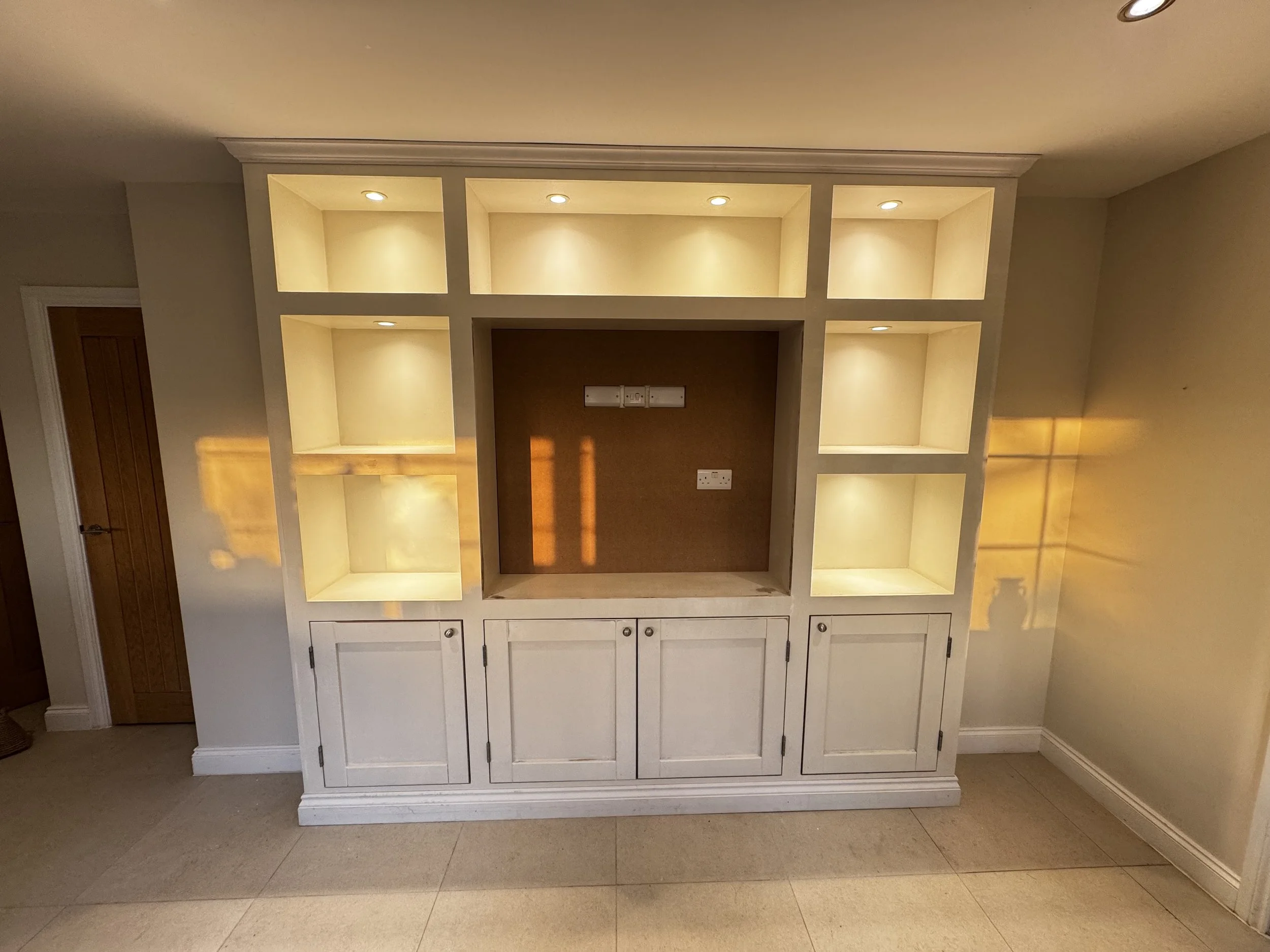 Handmade media walls with storage cupboards and lighting fixtures.