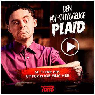 Man with a skeptical expression wearing a purple shirt holding a card in front of a black background with text in Danish advertising a comedy film.