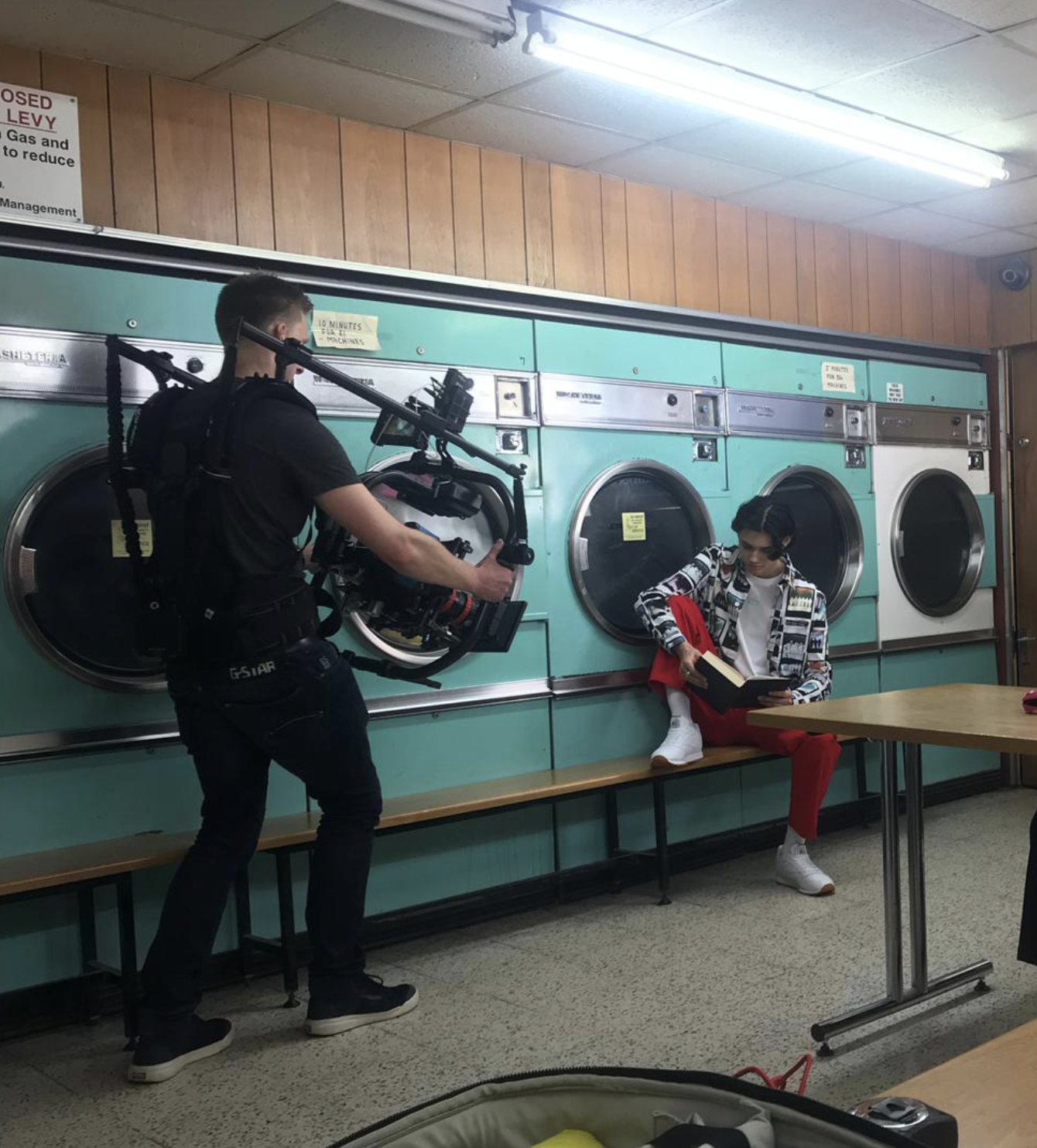 Behind-the-scenes filming for a fashion social campaign, shot on location in a laundromat.