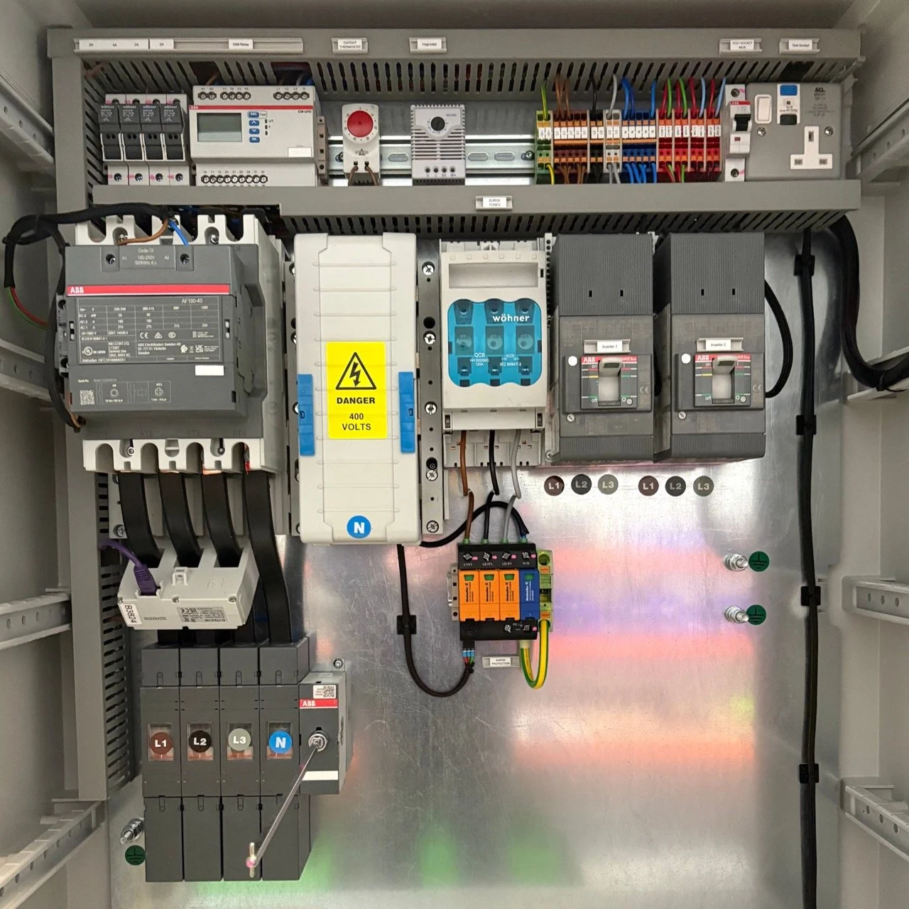 Expert switchgear suppliers with proven industry experience . Electrical control panel with various switches, circuit breakers, and wiring inside a metal enclosure.