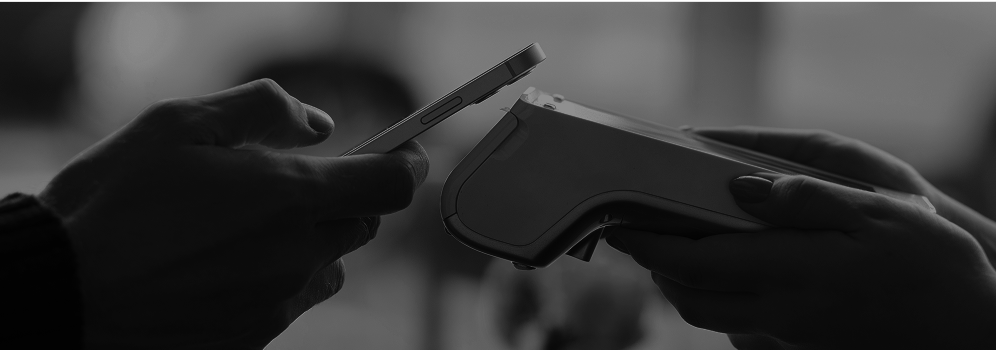 A person tapping a phone on a payment terminal