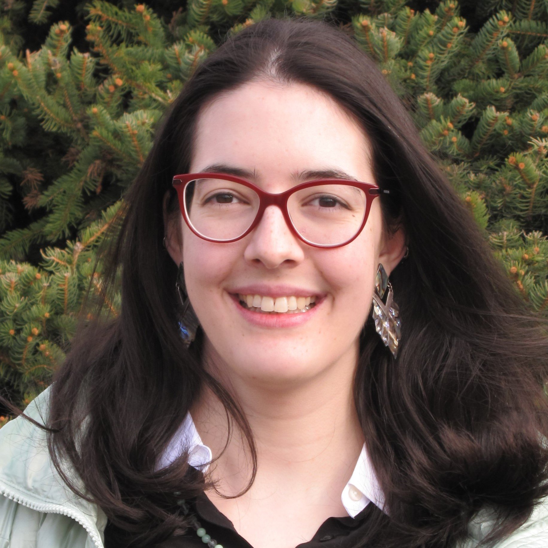 Anna Strohmeyer smiling in black shirt and wearing red glasses