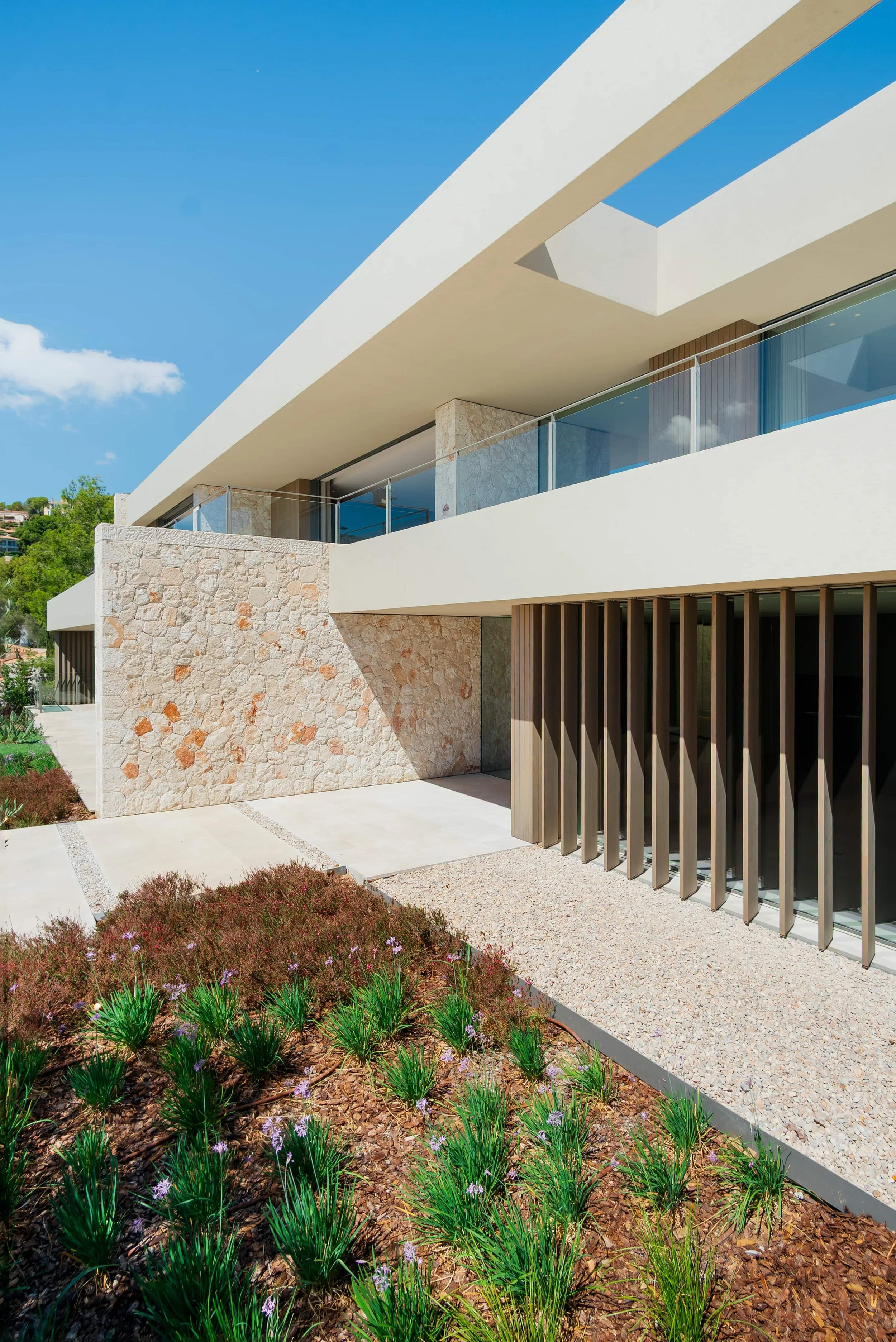 Contemporary villa facade with local stone and timber louvres, Mallorca