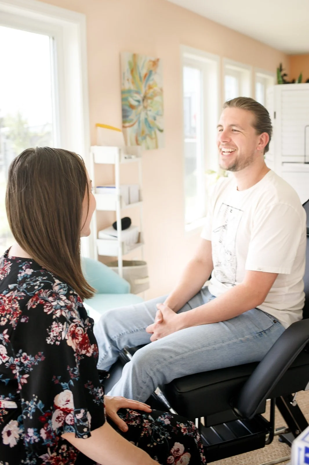 brianna sitting across from patient in her studio doing a consultation