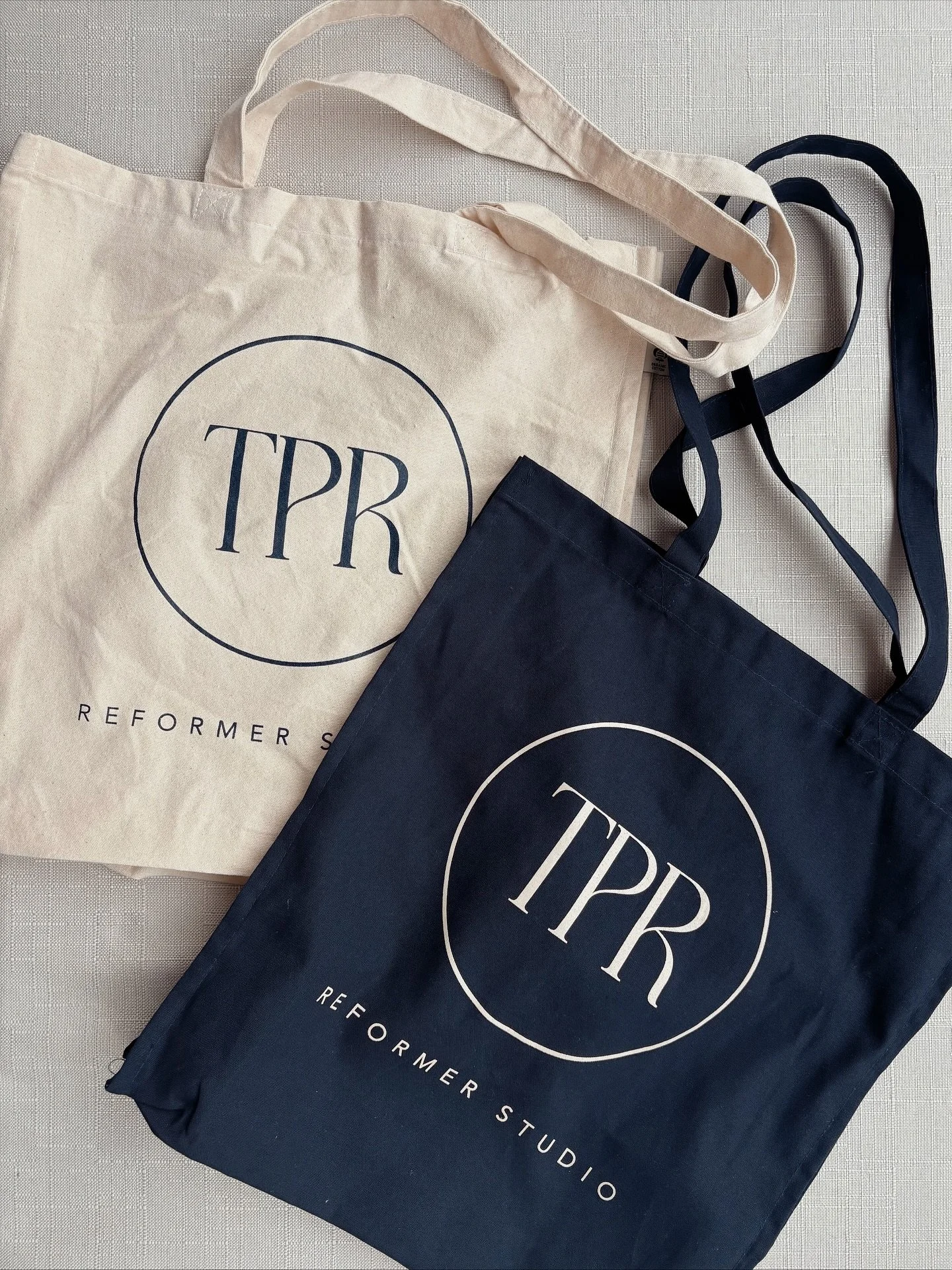 Our first TPR merch drop has landed!
These gorgeous organic-cotton totes come in French Navy or Natural and are the perfect grab-and-go bag for your workout kit, water bottle, socks - whatever you need for class 👌

They&rsquo;re available to purchas