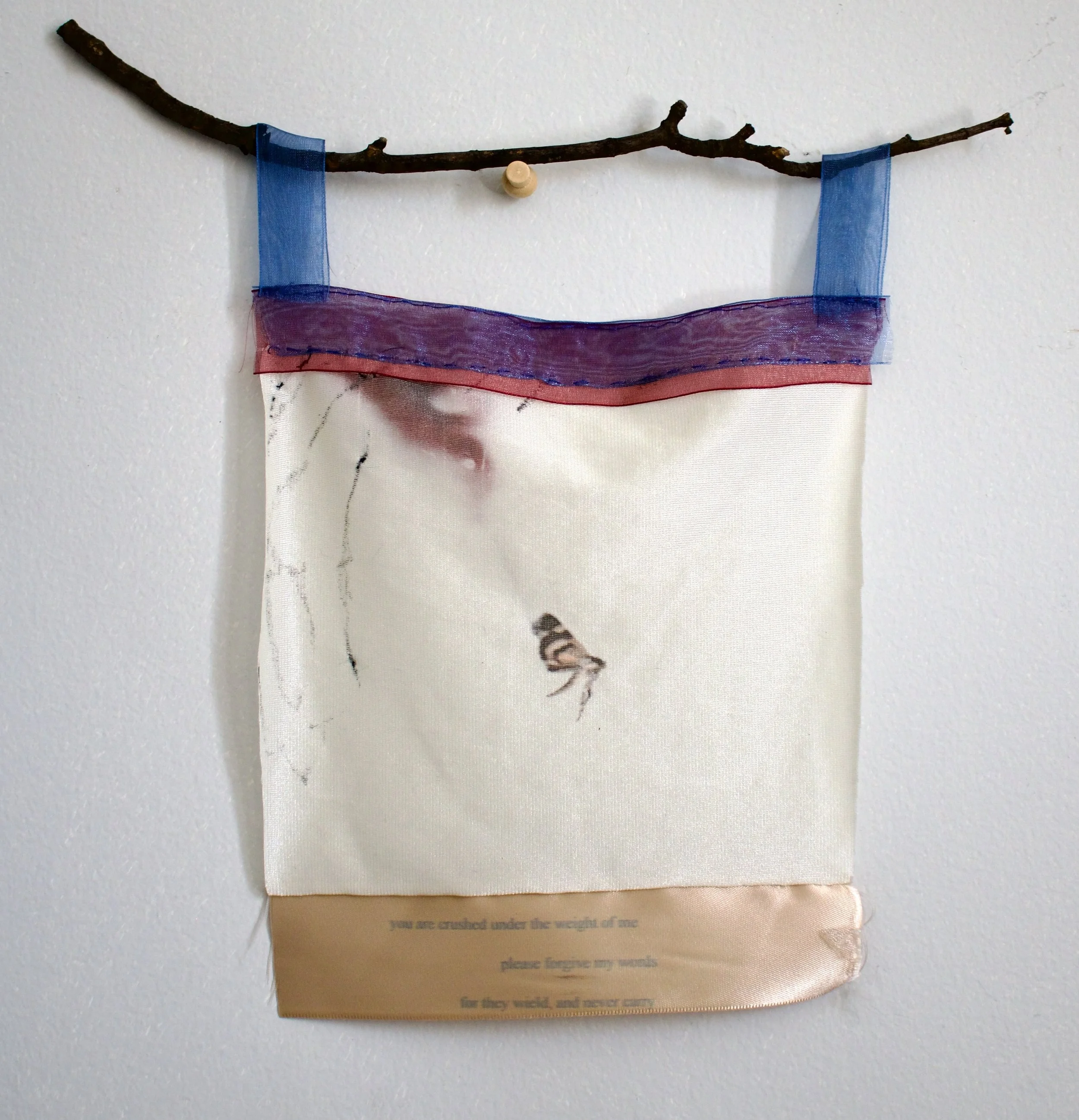 2025. "you are crushed under the weight of me." Inkjet printed found fabric, ribbon, branch. 10 inches long, 7 inches wide. 