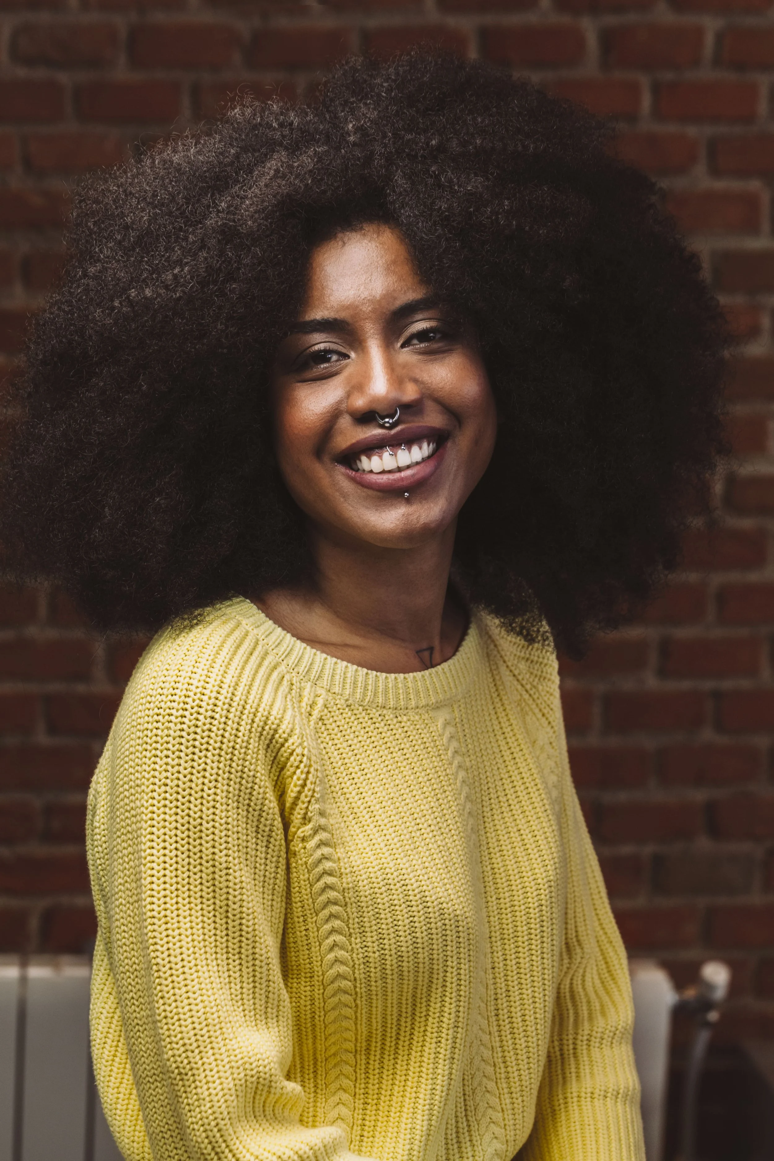 Mujer negra segura sonriente en una oficina urbana moderna