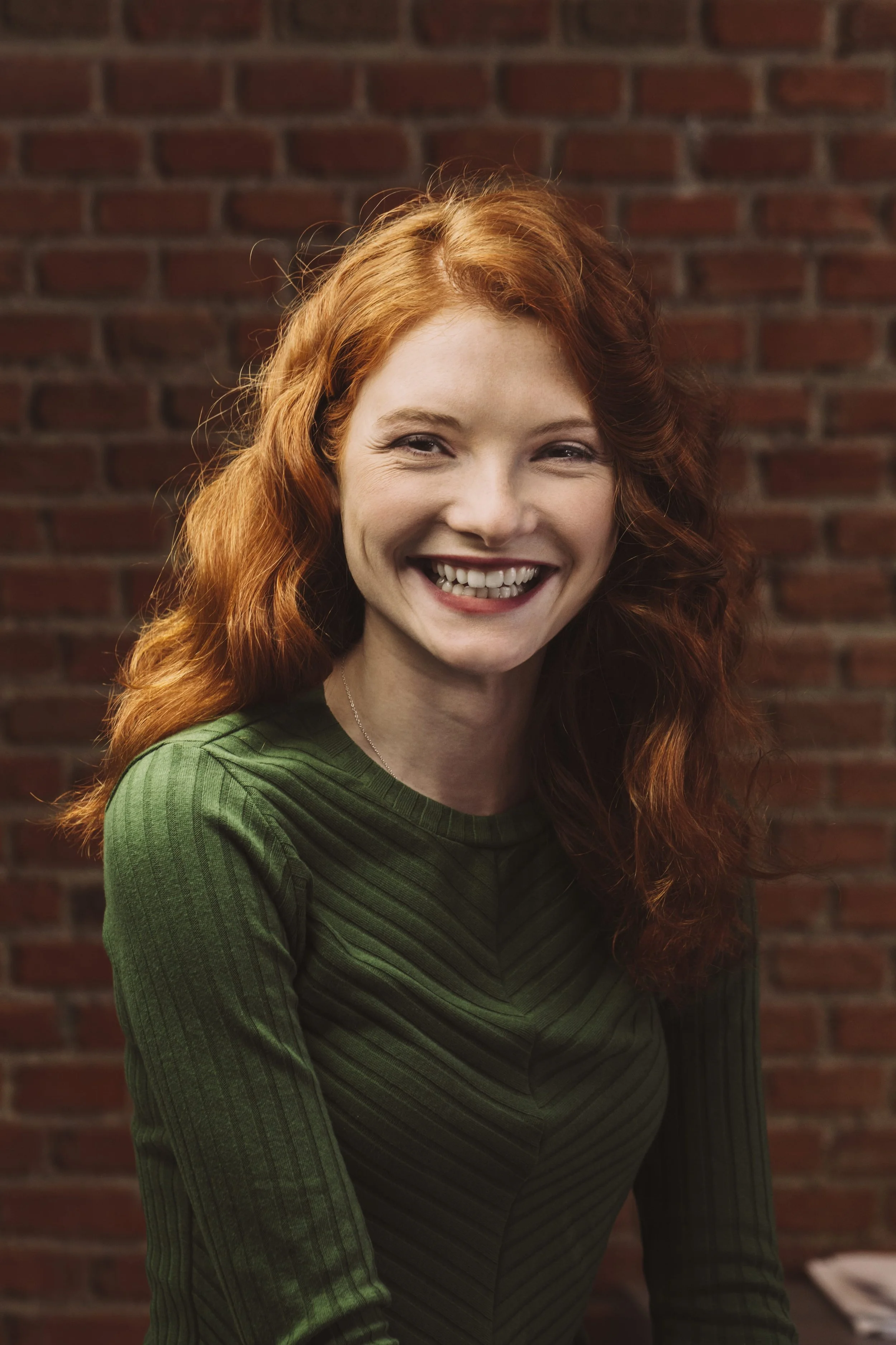 Junge lächelnde weiße Frau in modernem städtischen Büro