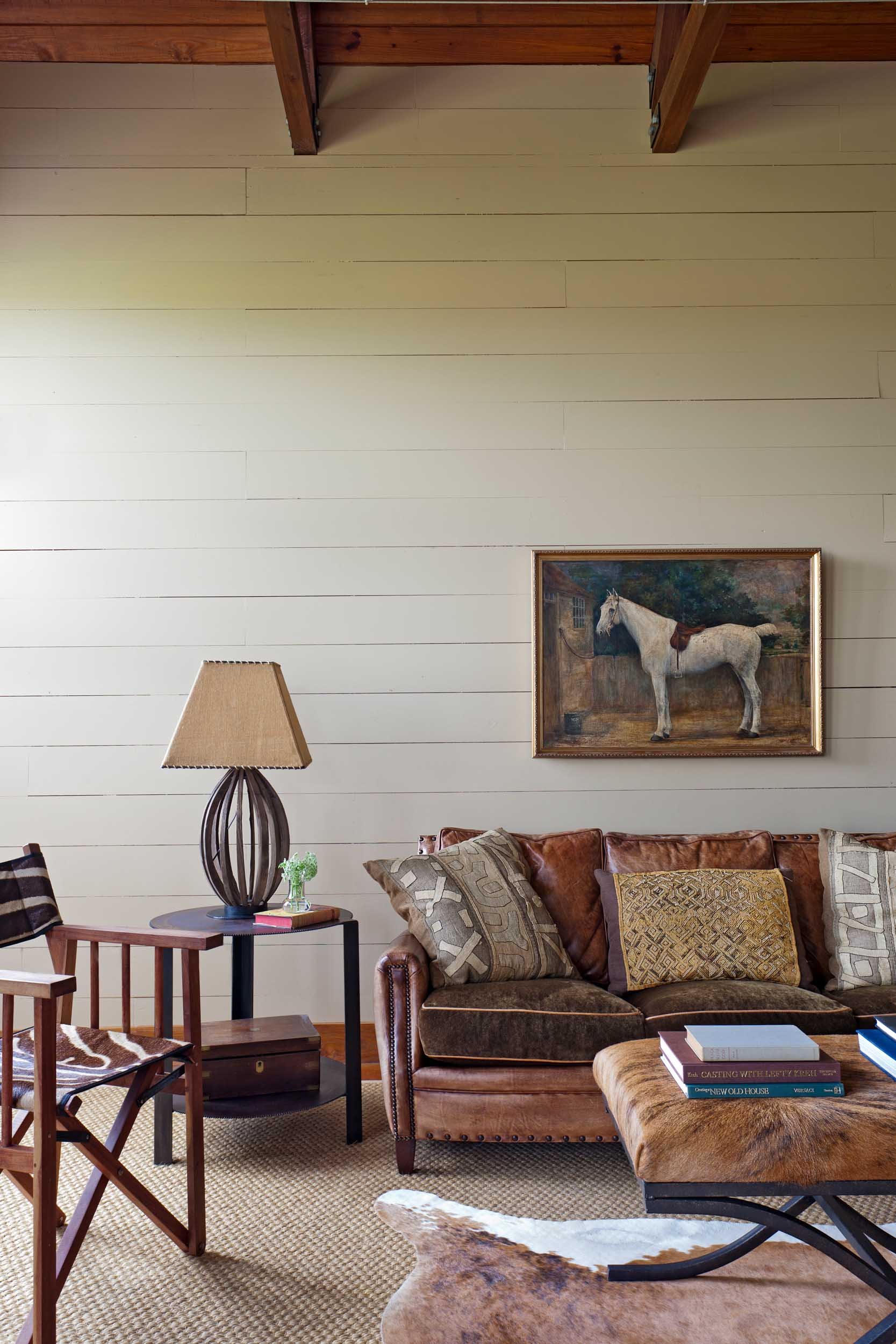 vintage-horse-painting-leather-sofa-in-paneled-den.jpg