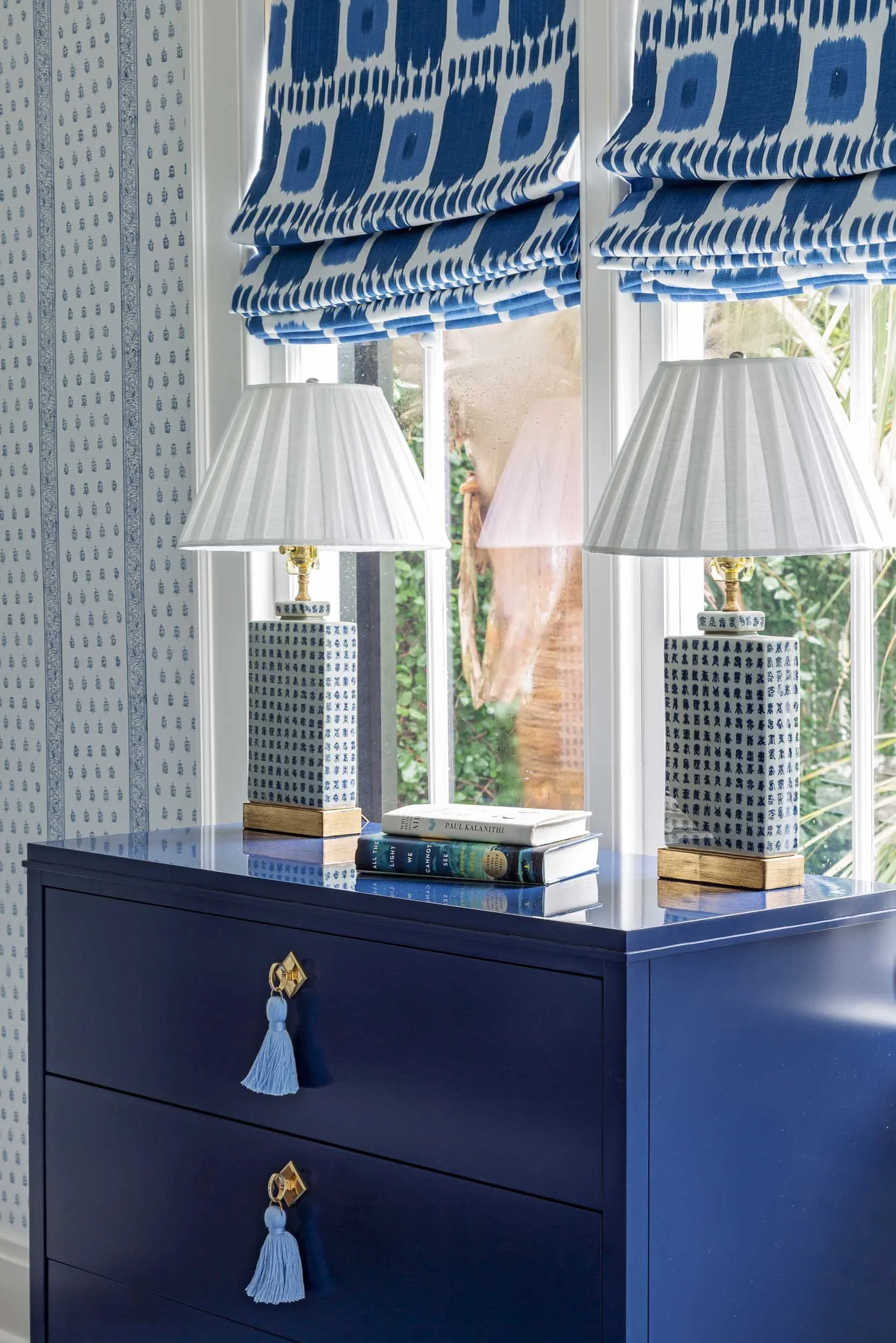 pair-of-vintage-lamps-and-custom-roman-shades-add-finishing-touches-to-white-and-blue-centric-bedroom.jpg
