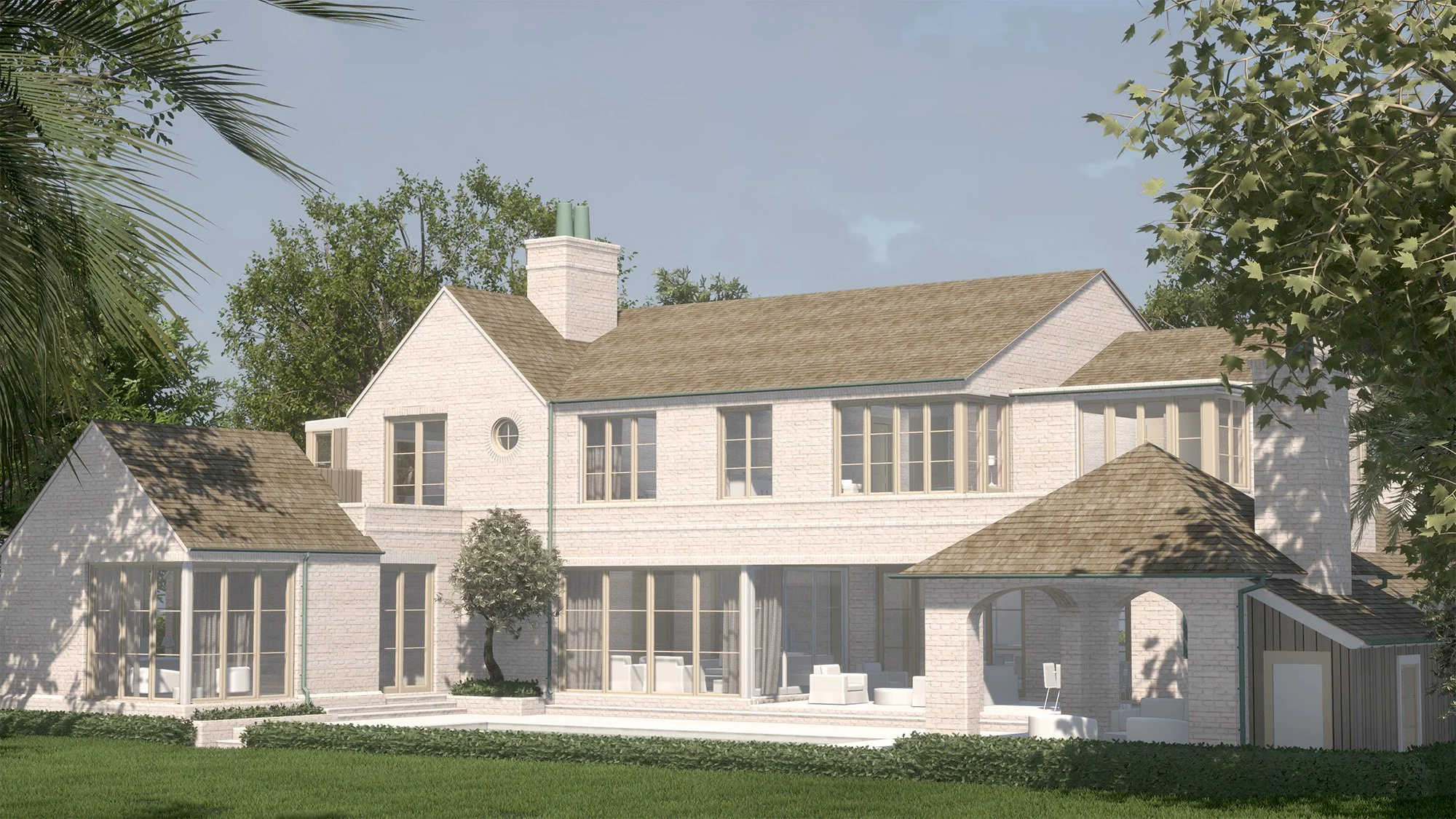 A two-story house with a white brick exterior and a tan shingle roof, surrounded by green trees and lawn, with an outdoor seating area under a covered patio.