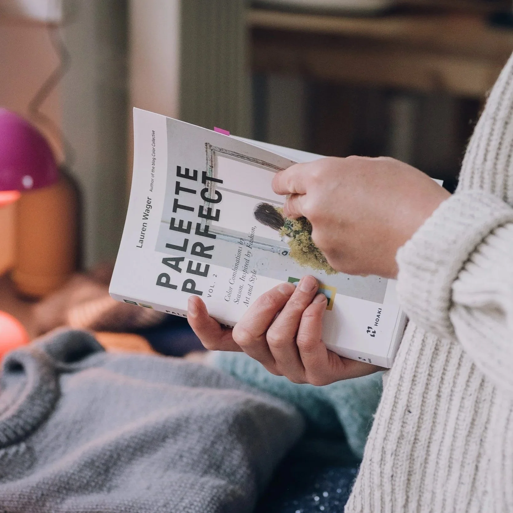 Strickkurs der Stitch Connection in Münster – Teilnehmerin stöbert in Strickanleitungen und findet Inspiration für neue Projekte. Stricken lernen & Ideen teilen.