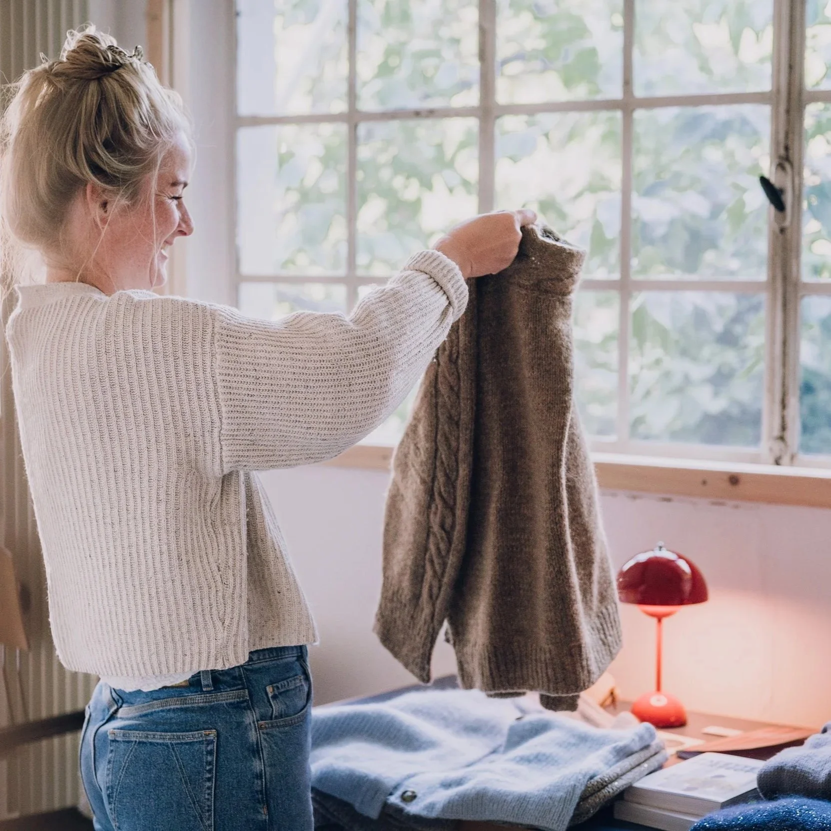 Frau im Strickkurs der Stitch Connection in Münster betrachtet ihr Strickstück und überprüft die Maschen.
