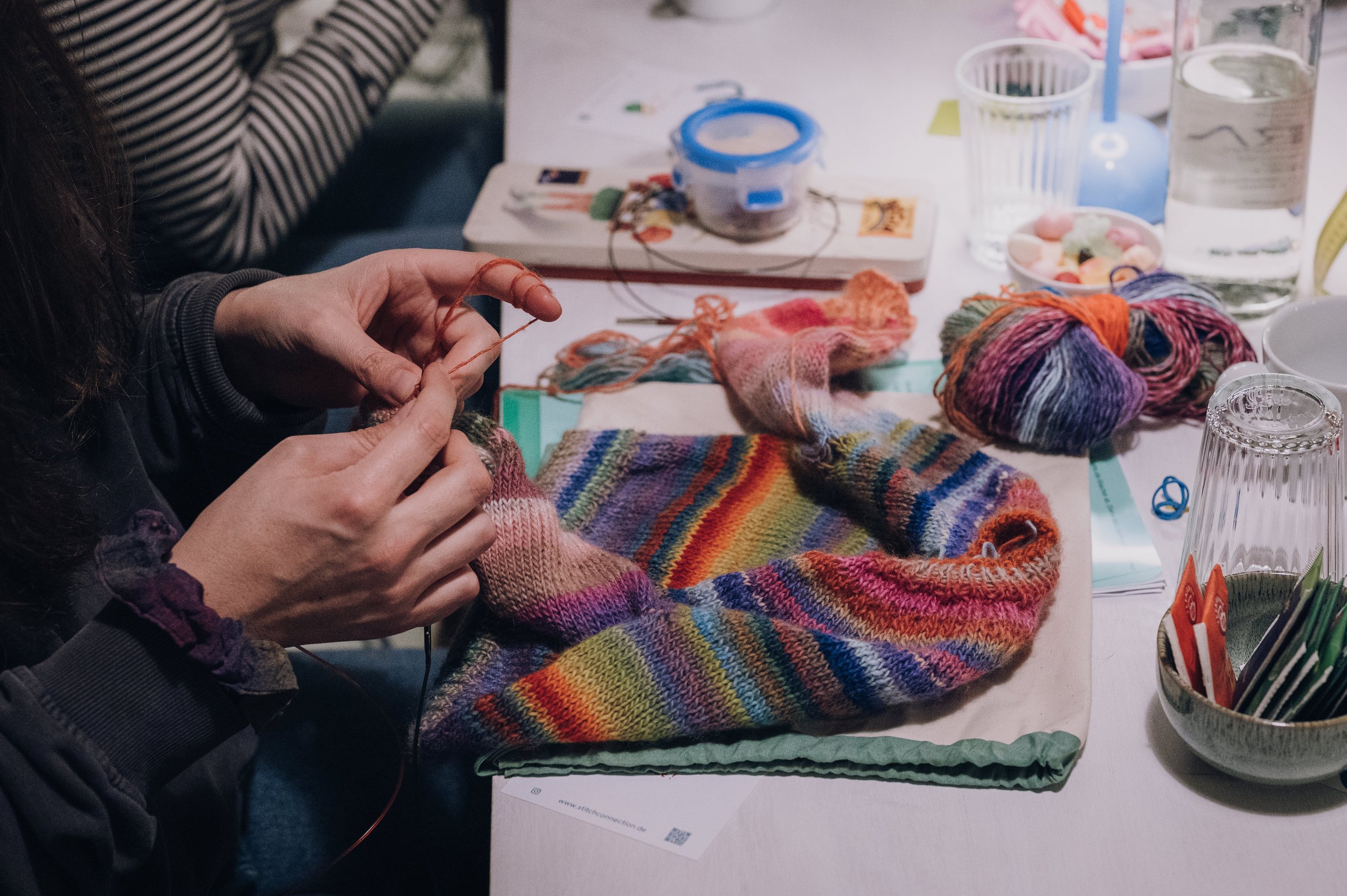 Gruppe von Frauen strickt gemeinsam an einem bunten Strickprojekt bei einem Strickevent in Münster.