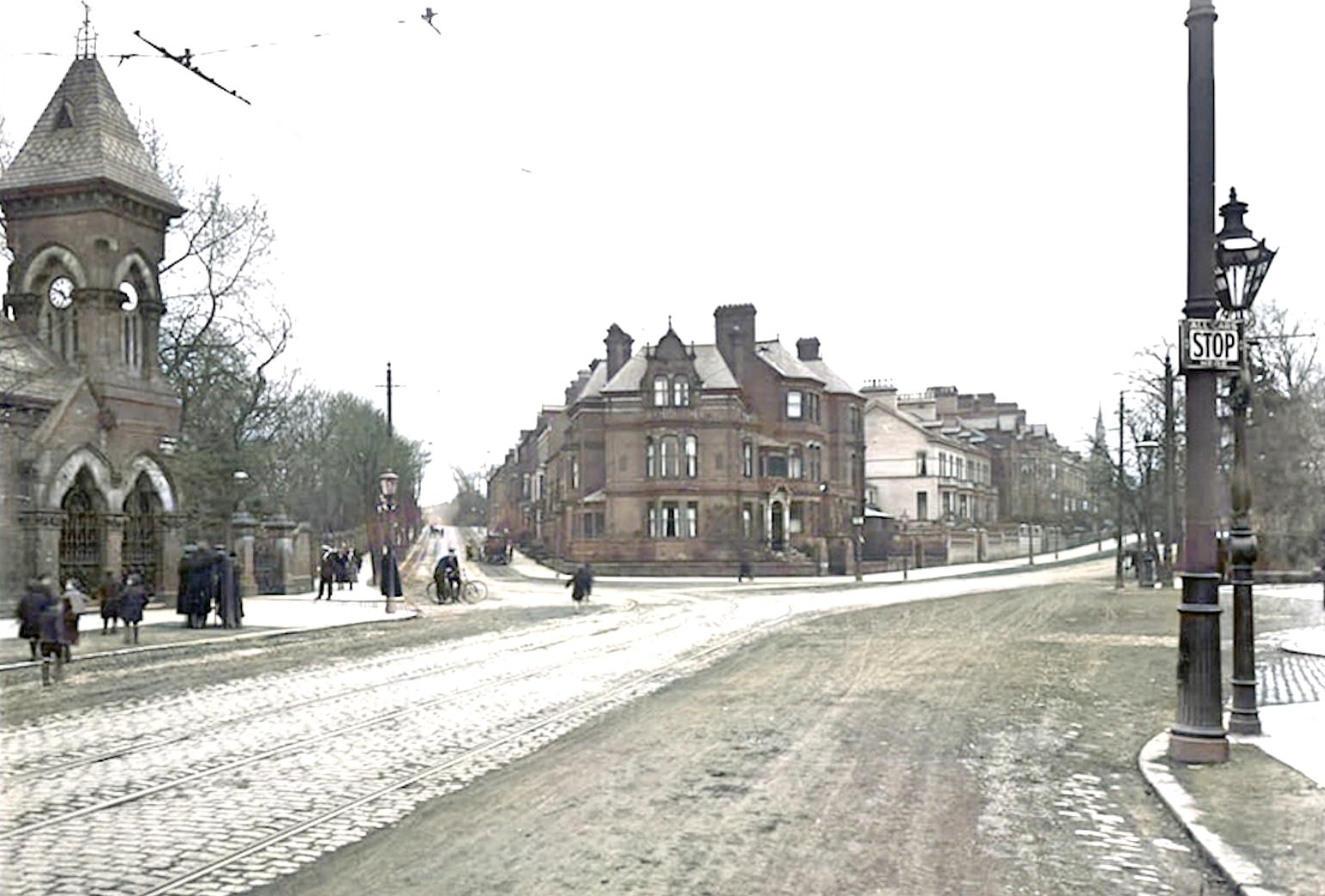 Historical street scene featuring cobblestone road, pedestrians, and horse-drawn carriages, with Victorian-style buildings and a church tower in the background.