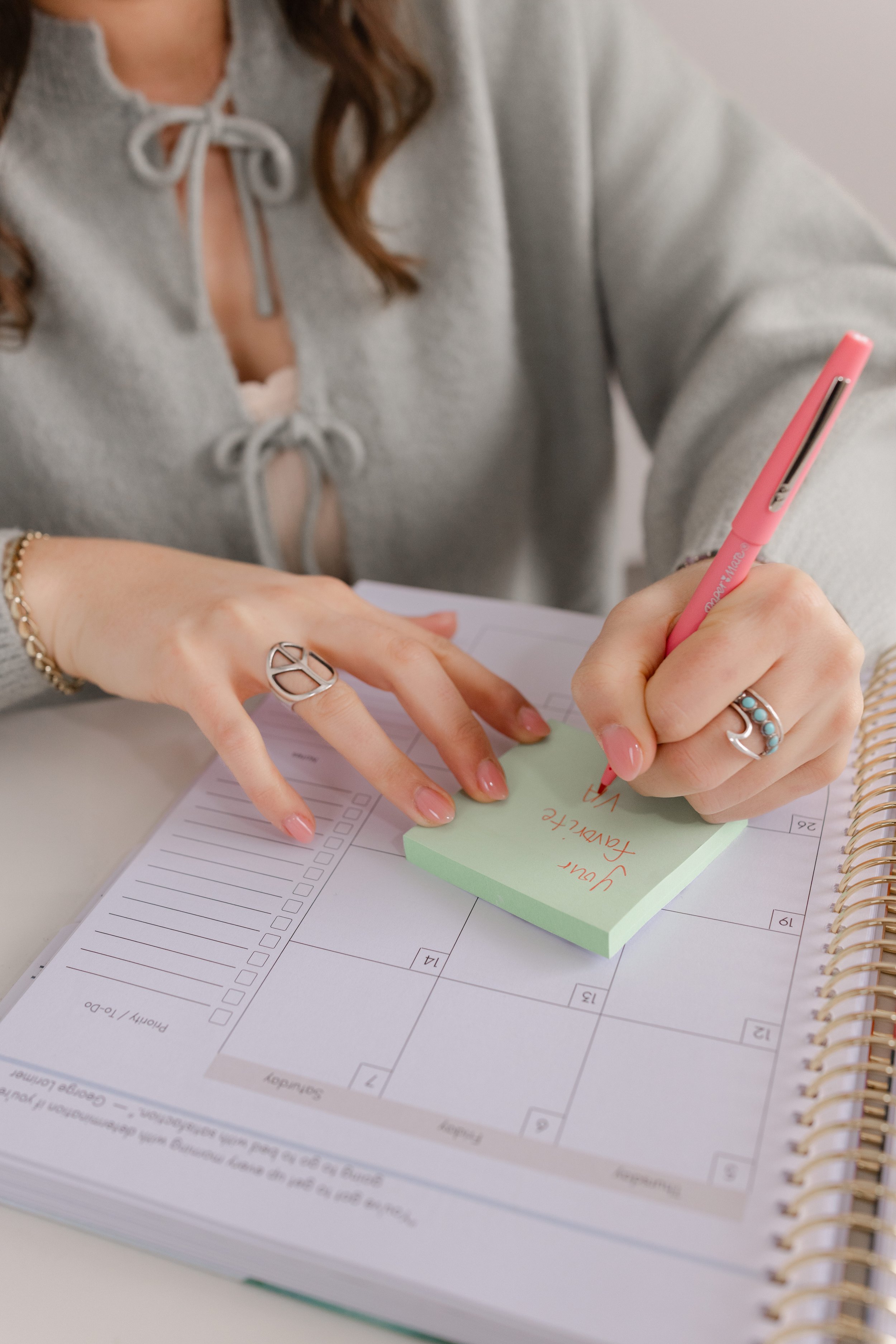 Woman writing on a post-it at office desk