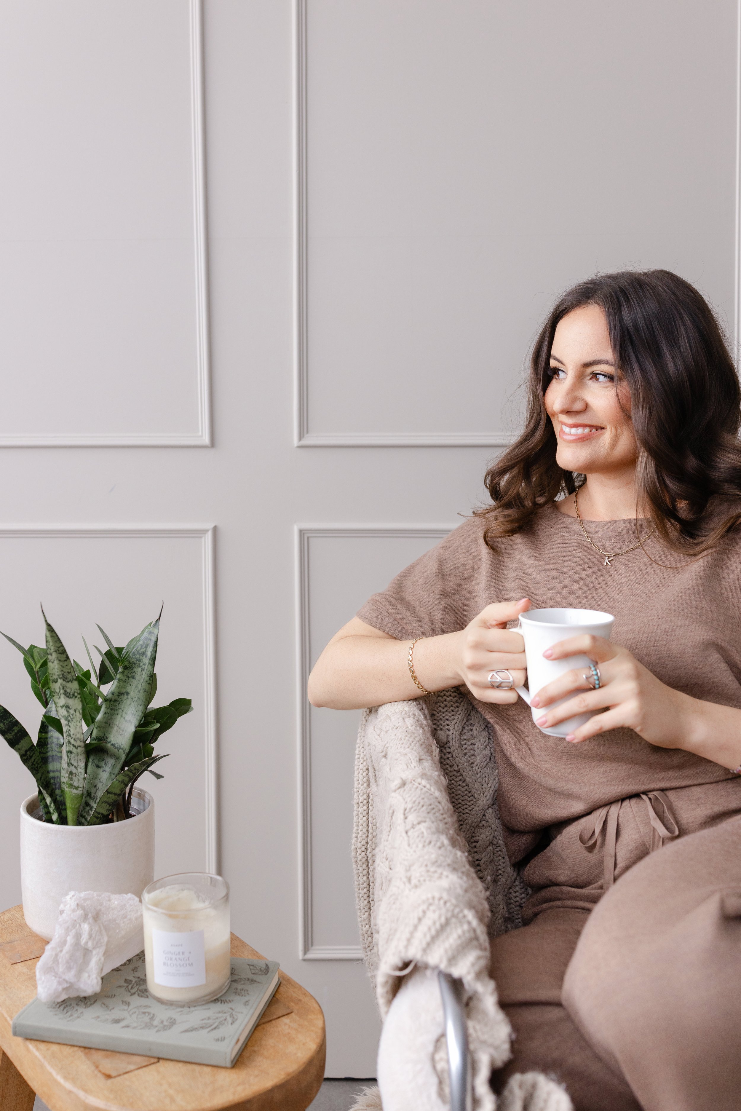 Woman sitting in living room chair drinking tea and looking out the window