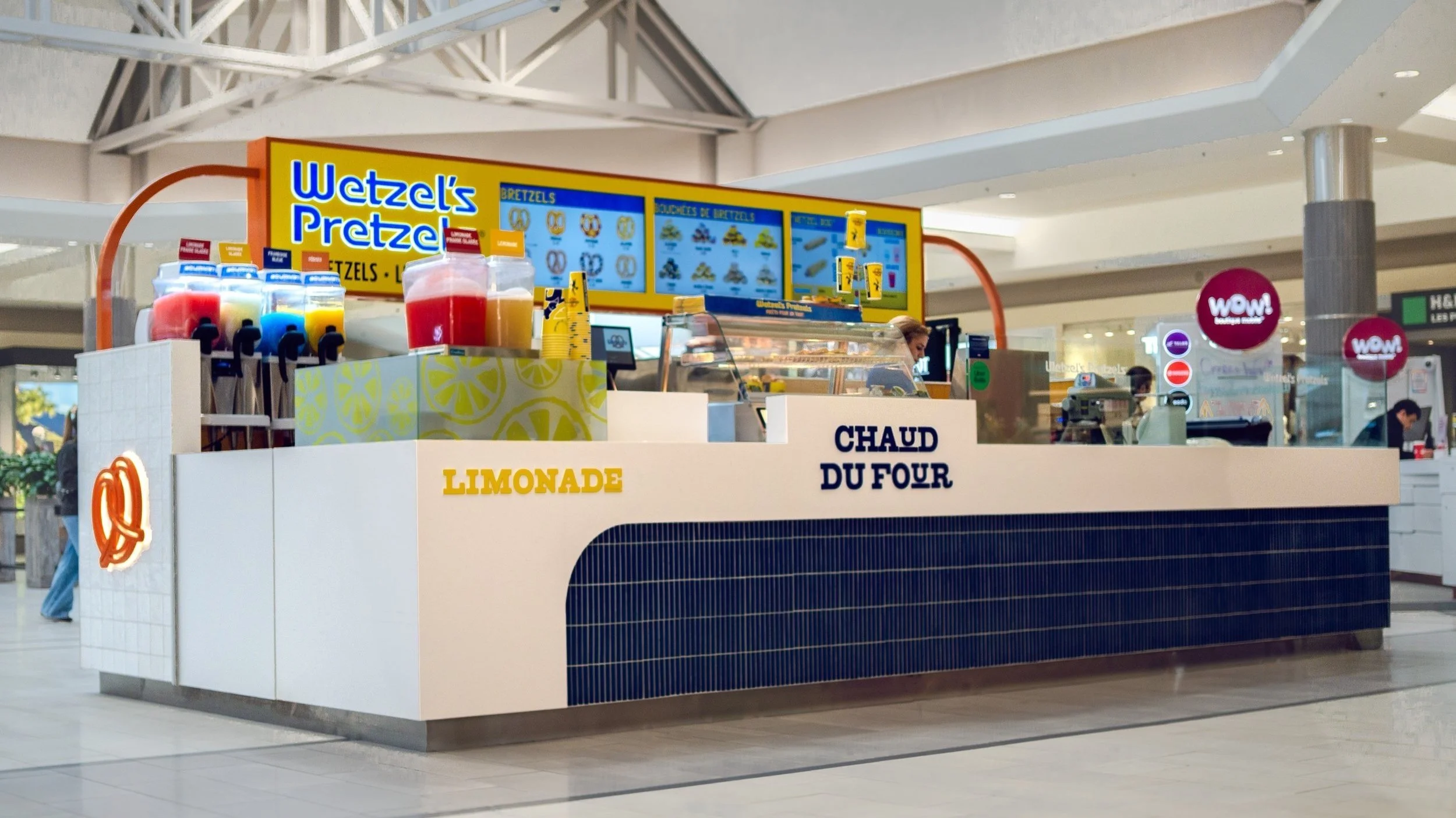 A pretzel stand named Wetzel's Pretzels offering lemonade and hot pretzels in a shopping mall.