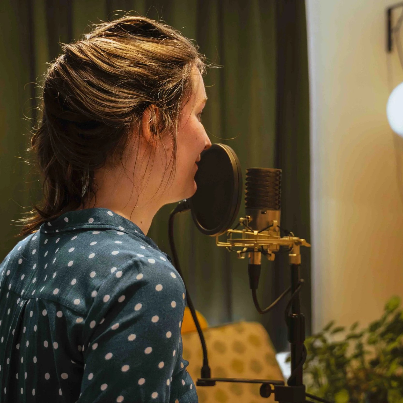 Een groep muzikanten speelt op een podium met een zangeres en zanger, achtergrondverlichting en digitale displays met reclame en informatie.