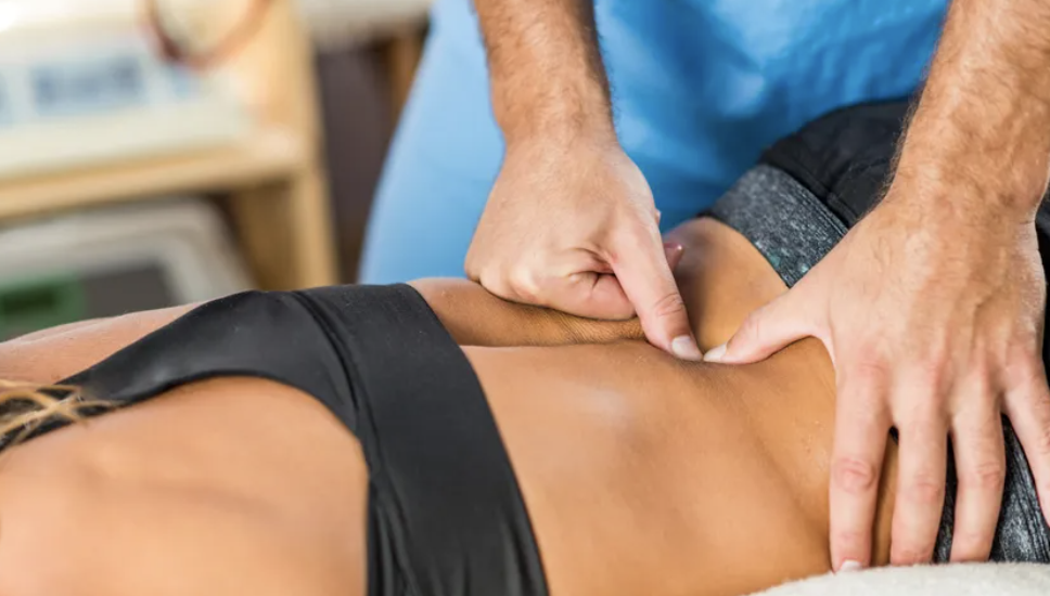 Chiropractor evaluating lower back pain after car accident in Andover MA clinic
